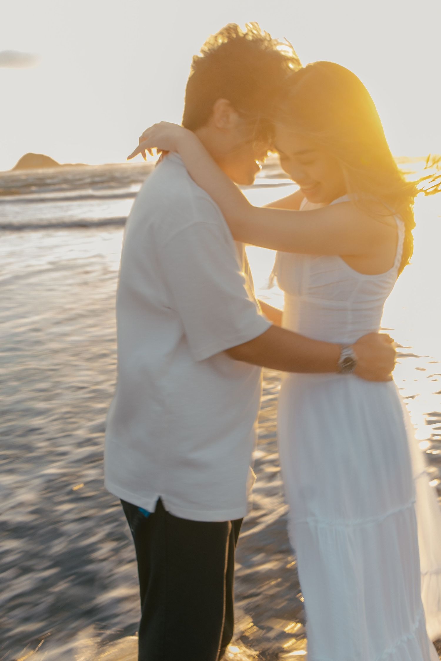 A couple photoshoot session during a magical sunset at Muriwai Beach by YM Photography.