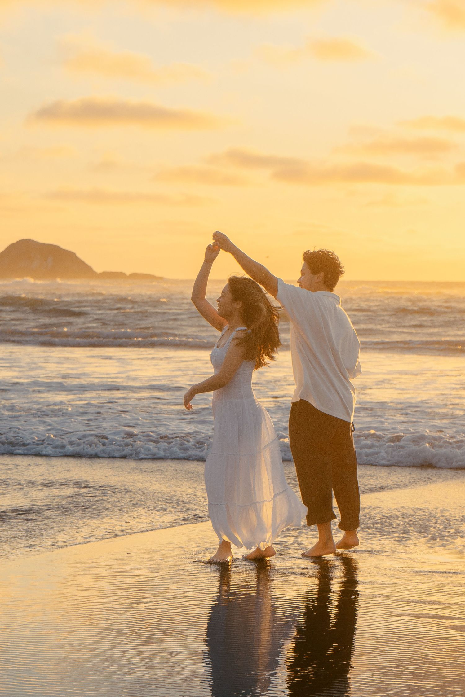 A couple photoshoot session during a magical sunset at Muriwai Beach by YM Photography.