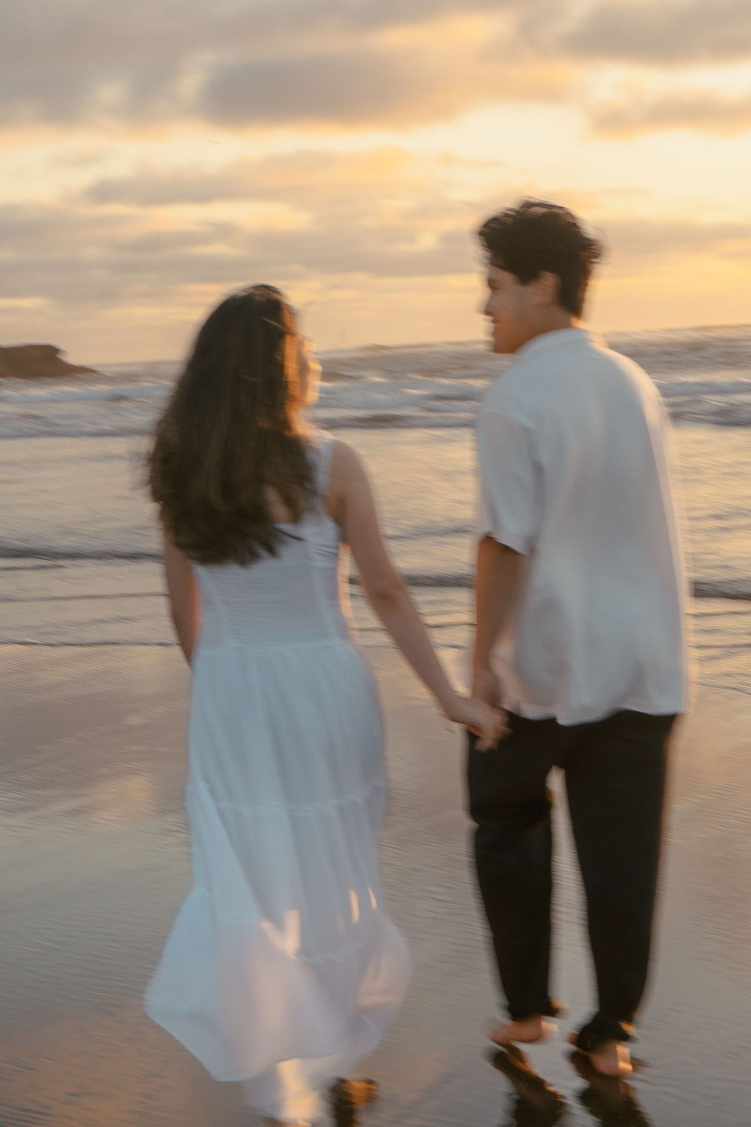 A couple photoshoot session during a magical sunset at Muriwai Beach by YM Photography.