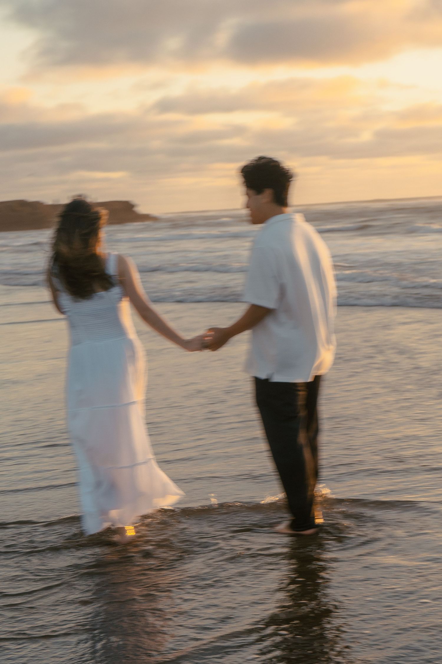 A couple photoshoot session during a magical sunset at Muriwai Beach by YM Photography.
