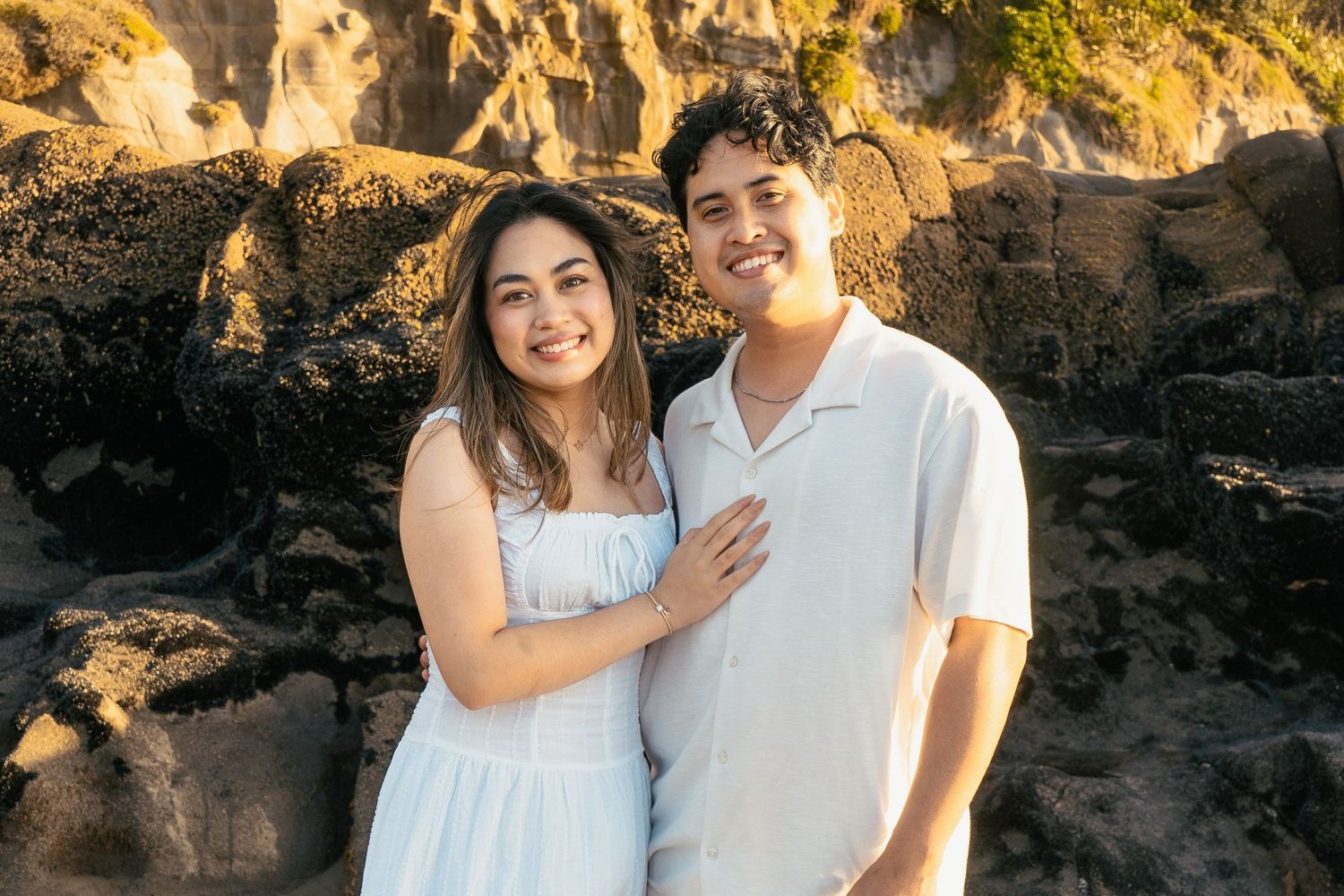 A couple photoshoot session during a magical sunset at Muriwai Beach by YM Photography.