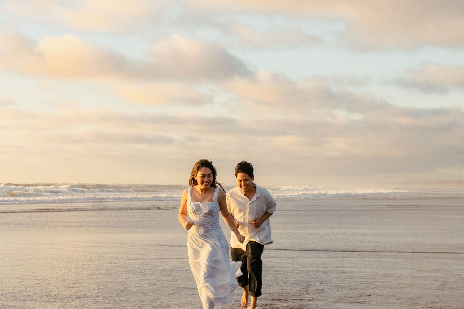 A couple photoshoot session during a magical sunset at Muriwai Beach by YM Photography.