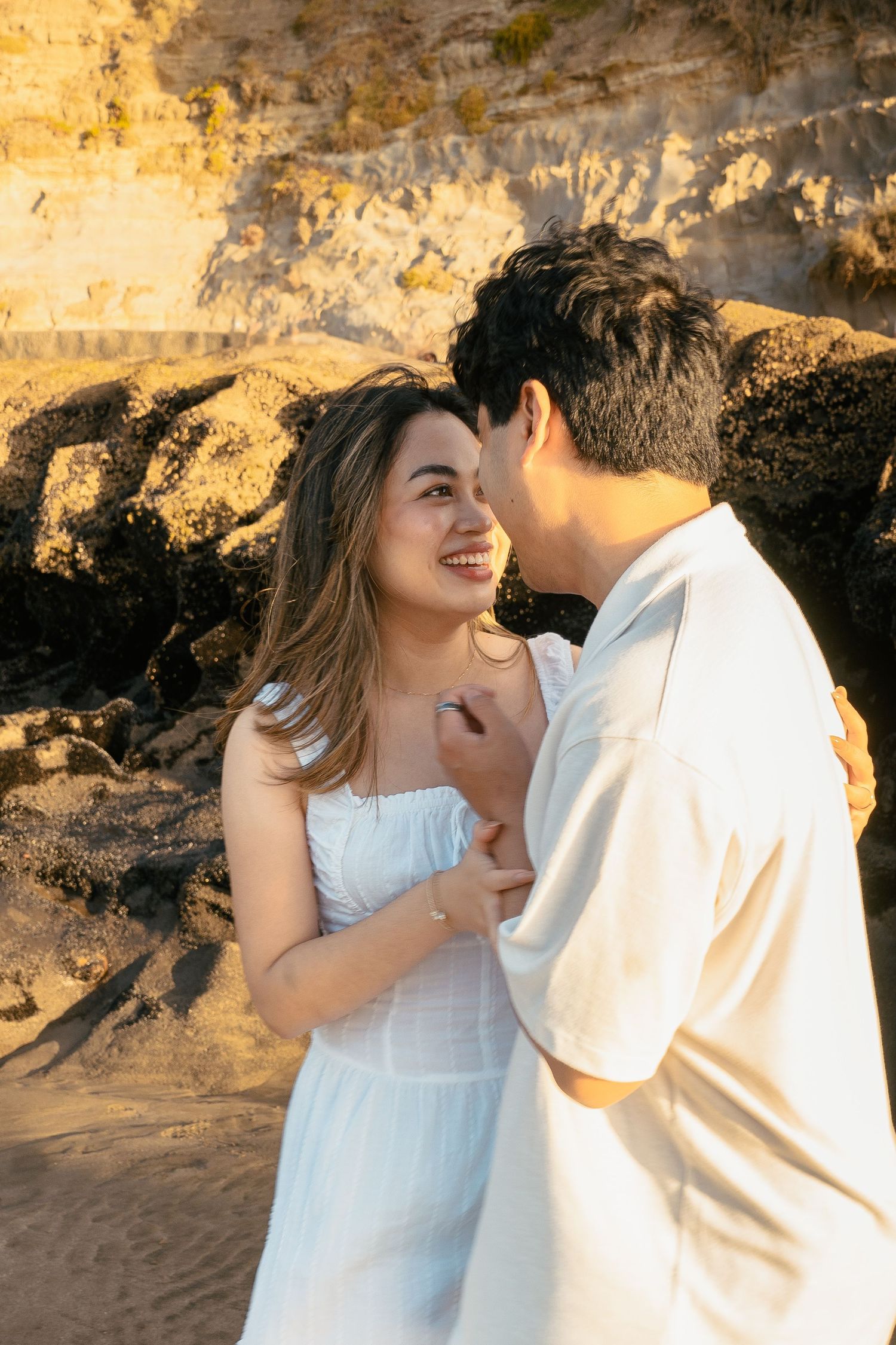 A couple photoshoot session during a magical sunset at Muriwai Beach by YM Photography.