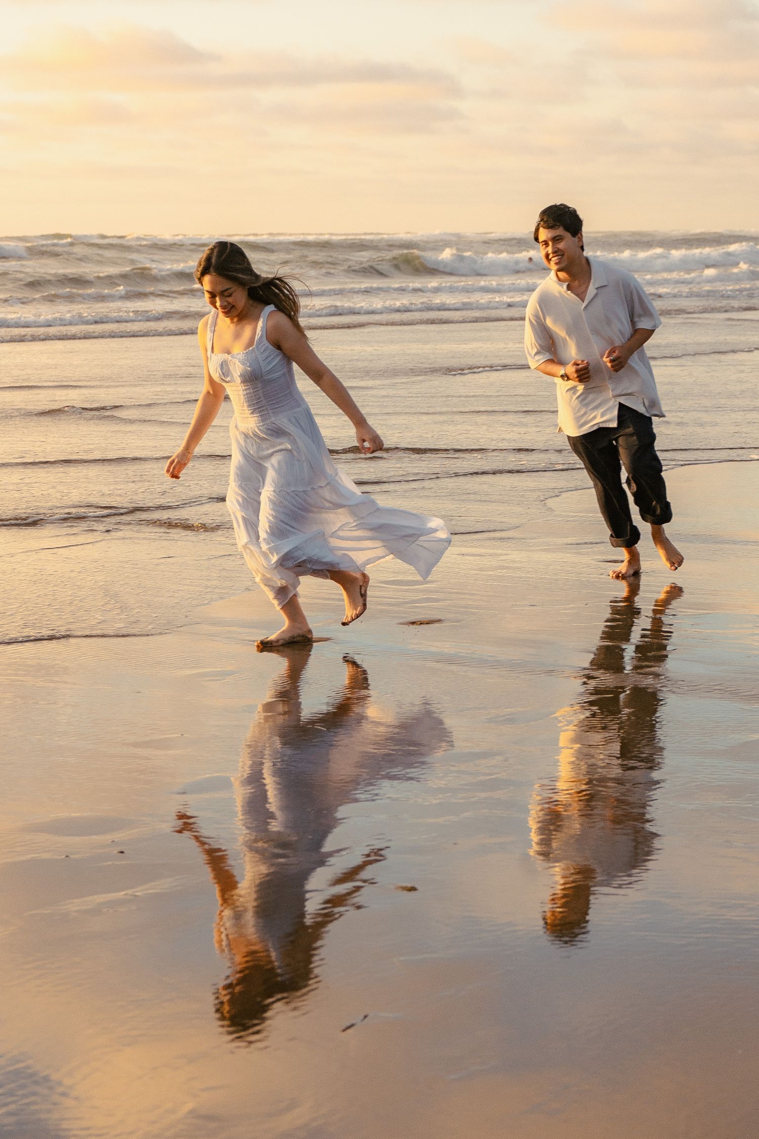 A couple photoshoot session during a magical sunset at Muriwai Beach by YM Photography.
