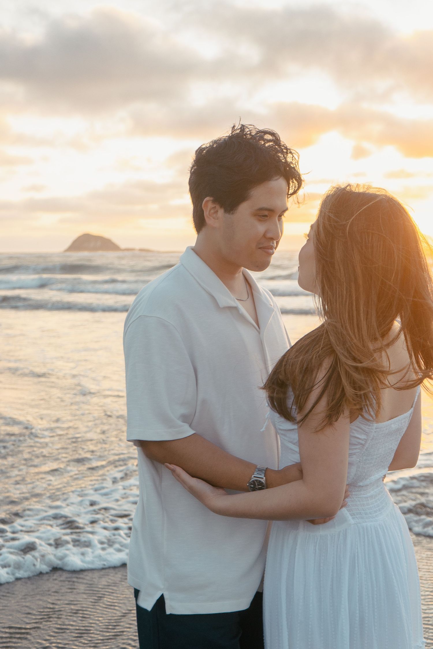 A couple photoshoot session during a magical sunset at Muriwai Beach by YM Photography.