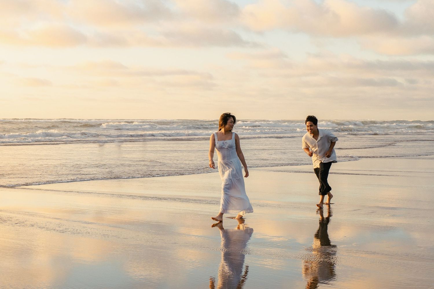A couple photoshoot session during a magical sunset at Muriwai Beach by YM Photography. Chasing sunsets