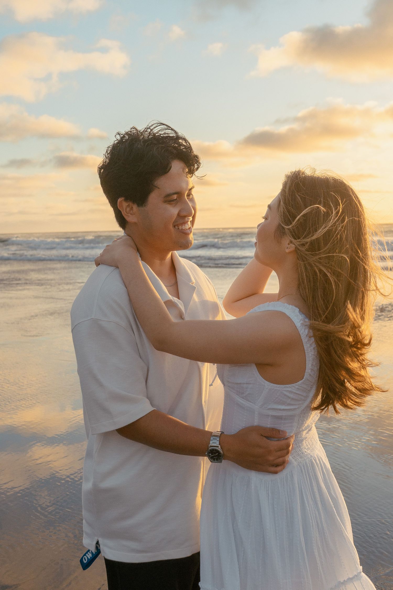 A couple photoshoot session during a magical sunset at Muriwai Beach by YM Photography.