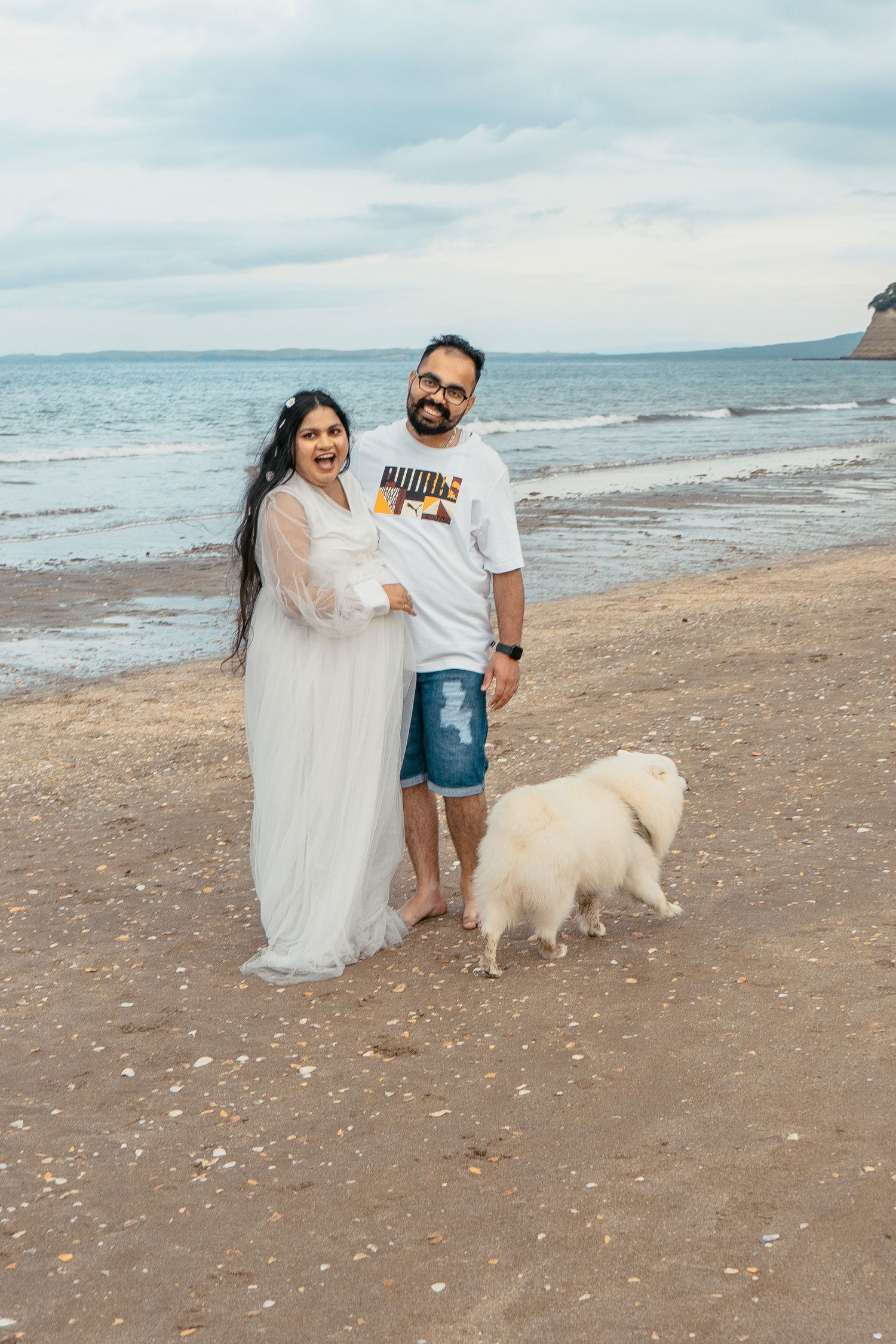 A gorgeous maternity shoot during sunset at Long Bay Beach, Auckland by YM Photography. White, flowy maternity dress used from Shein.