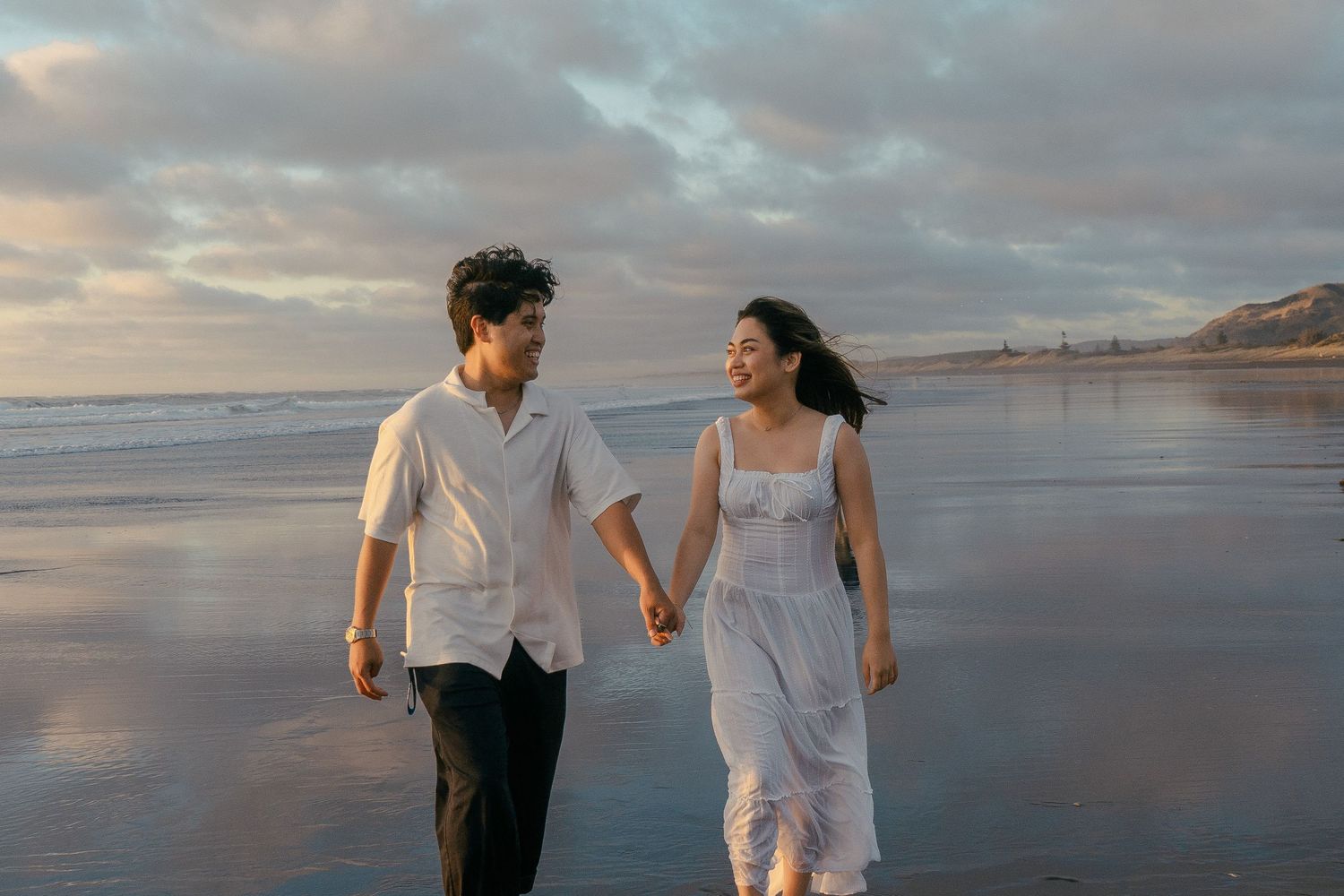A couple photoshoot session during a magical sunset at Muriwai Beach by YM Photography.