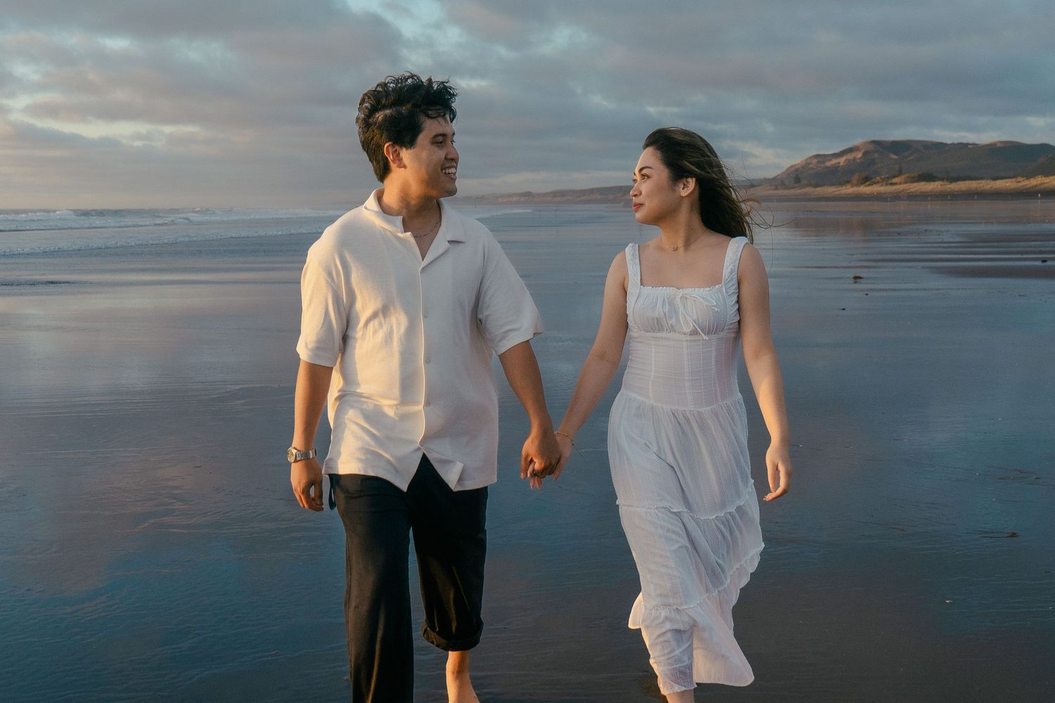 A couple photoshoot session during a magical sunset at Muriwai Beach by YM Photography.