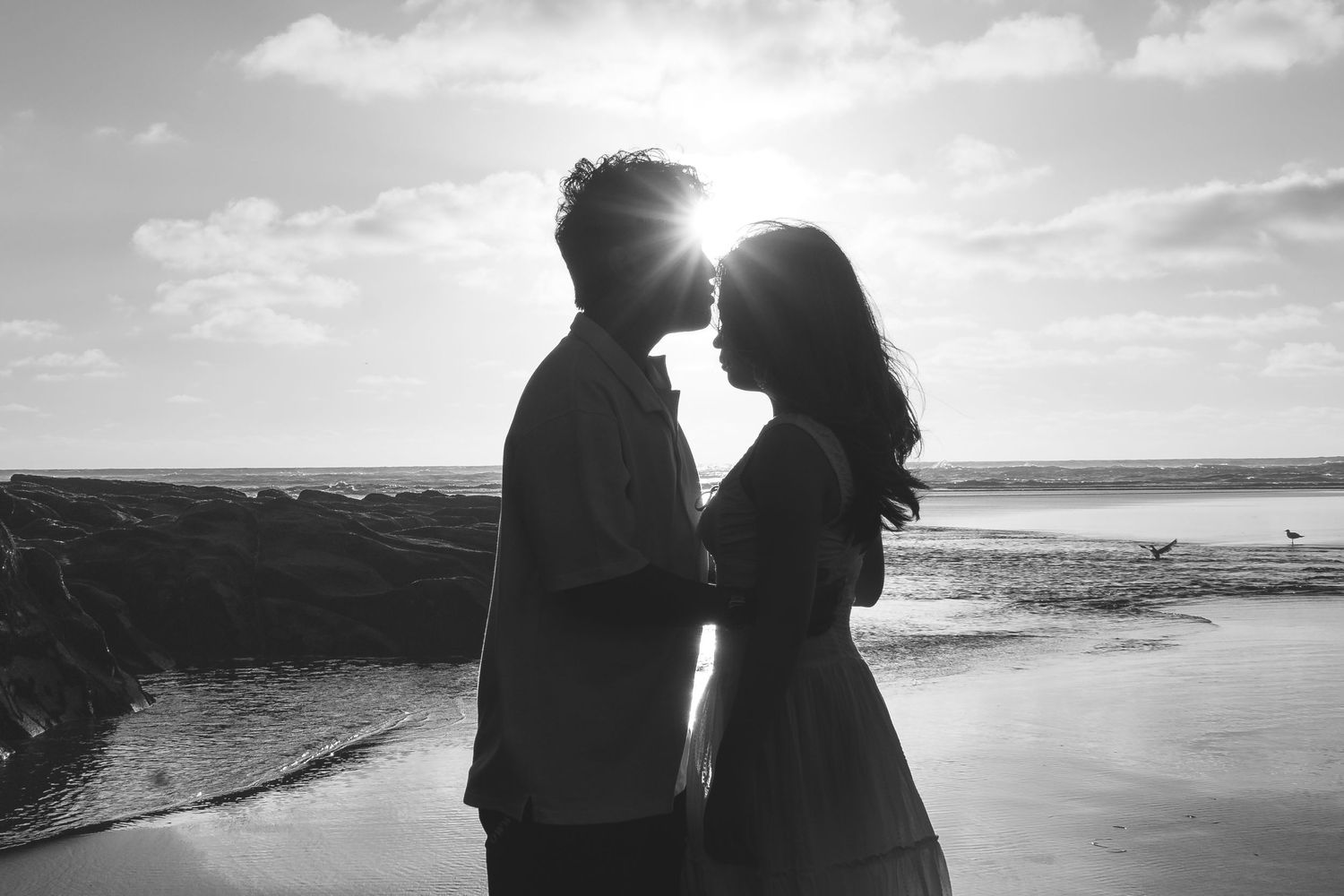 A couple photoshoot session during a magical sunset at Muriwai Beach by YM Photography.