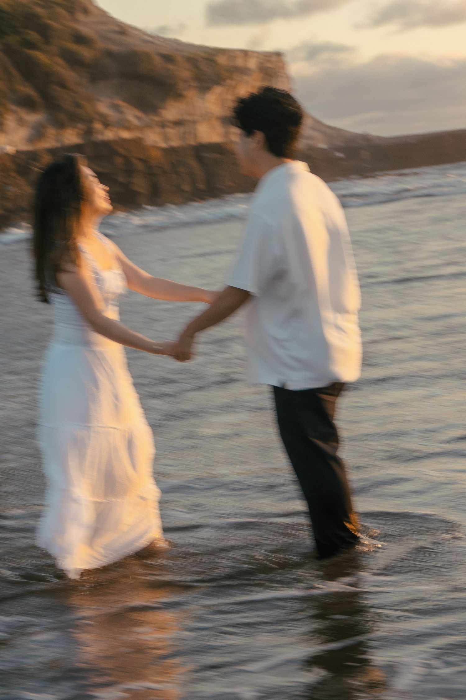 A couple photoshoot session during a magical sunset at Muriwai Beach by YM Photography.