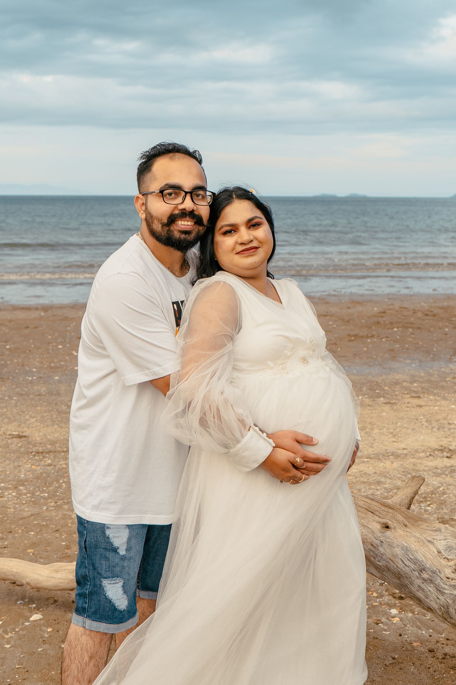 A gorgeous maternity shoot during sunset at Long Bay Beach, Auckland by YM Photography. White, flowy maternity dress used from Shein.
