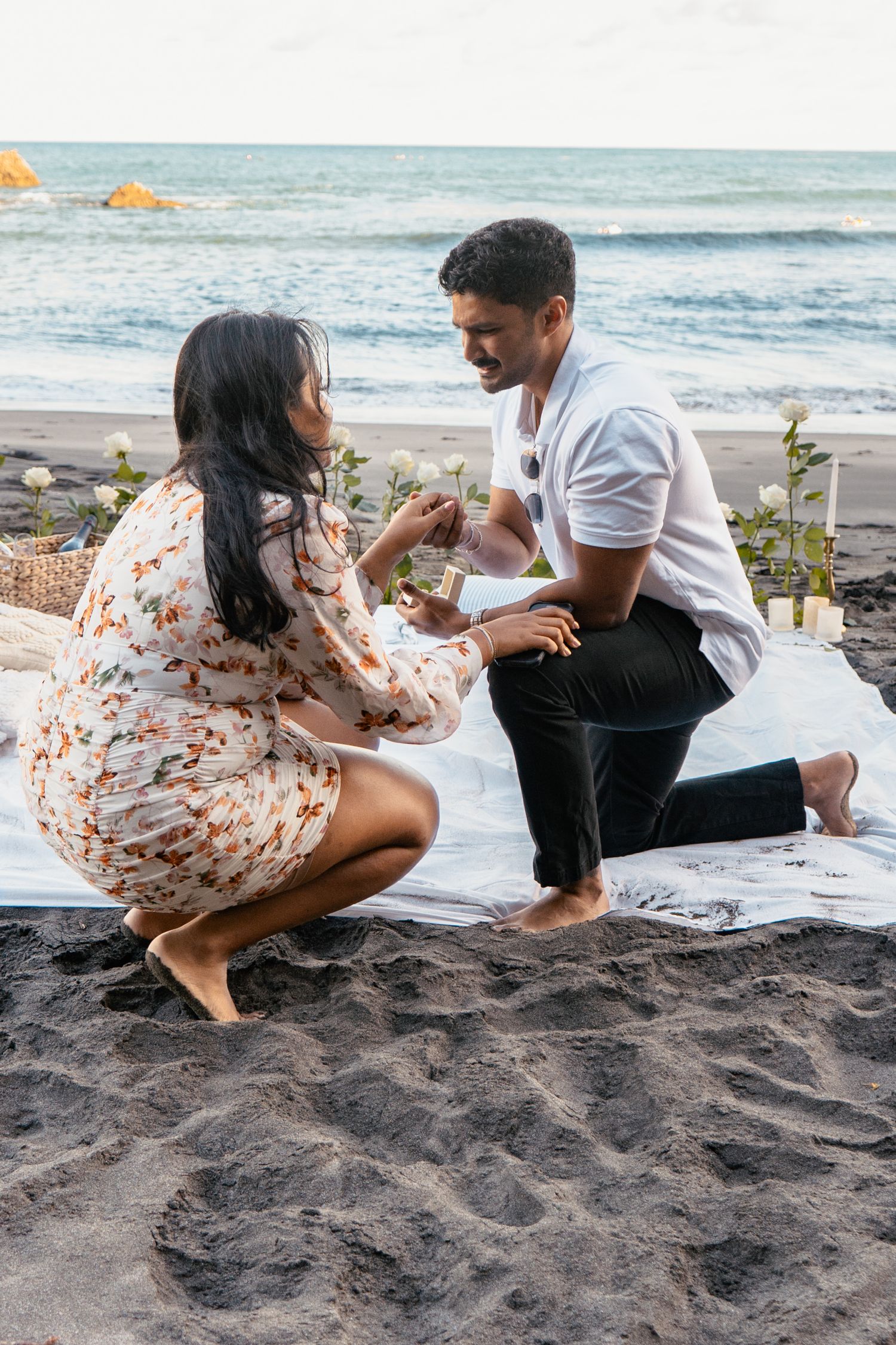 Surprise picnic proposal filled with tears and joy at Piha beach shot by YM Photography. Shot on digital and 35mm film.