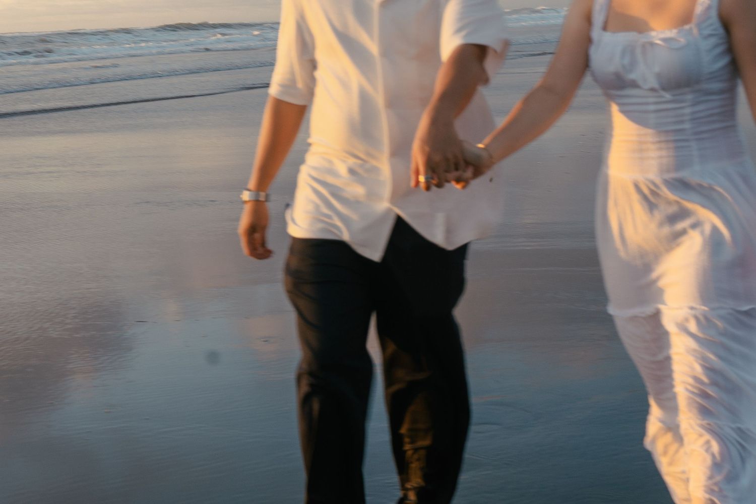 A couple photoshoot session during a magical sunset at Muriwai Beach by YM Photography.