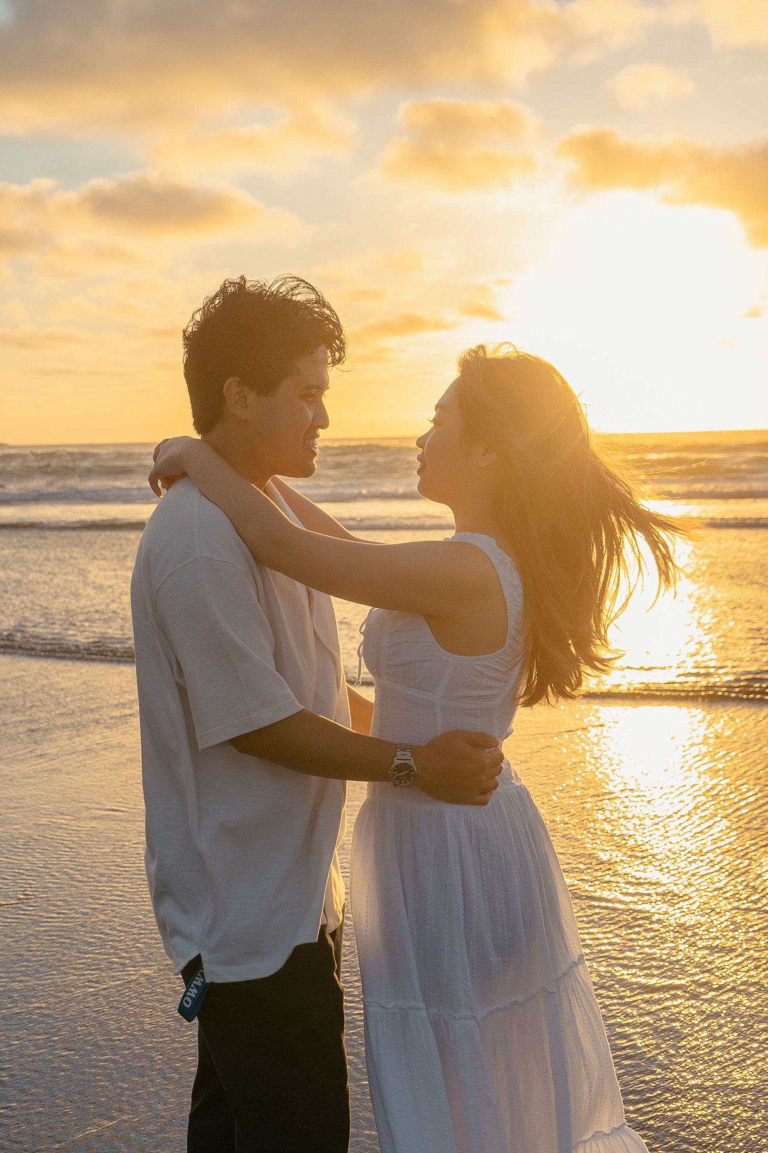 A couple photoshoot session during a magical sunset at Muriwai Beach by YM Photography.