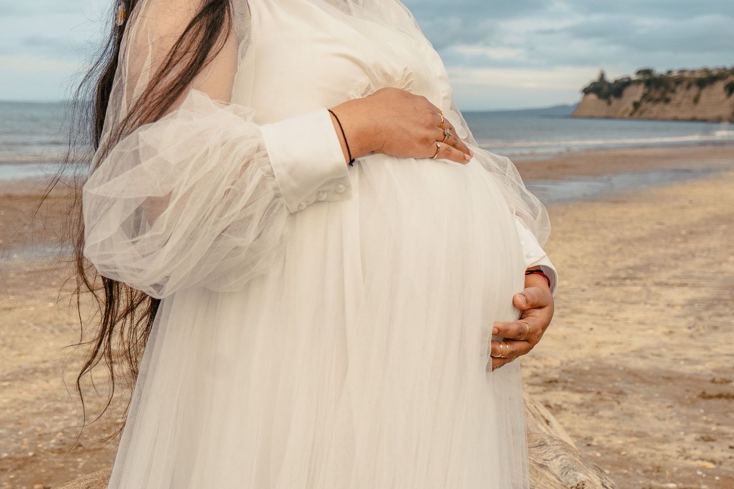 A magical maternity shoot during sunset at Long Bay Beach, Auckland.