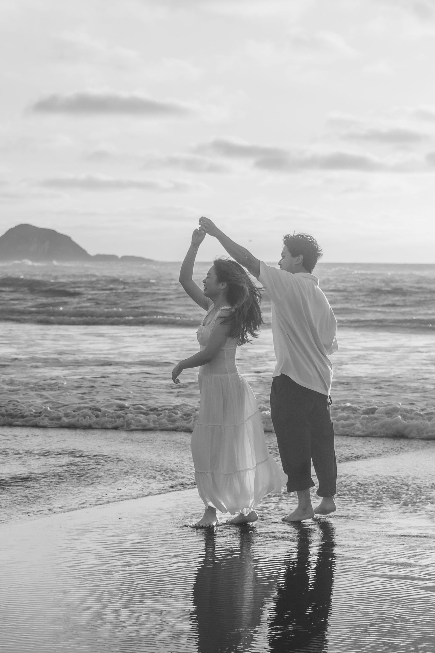 A couple photoshoot session during a magical sunset at Muriwai Beach by YM Photography.