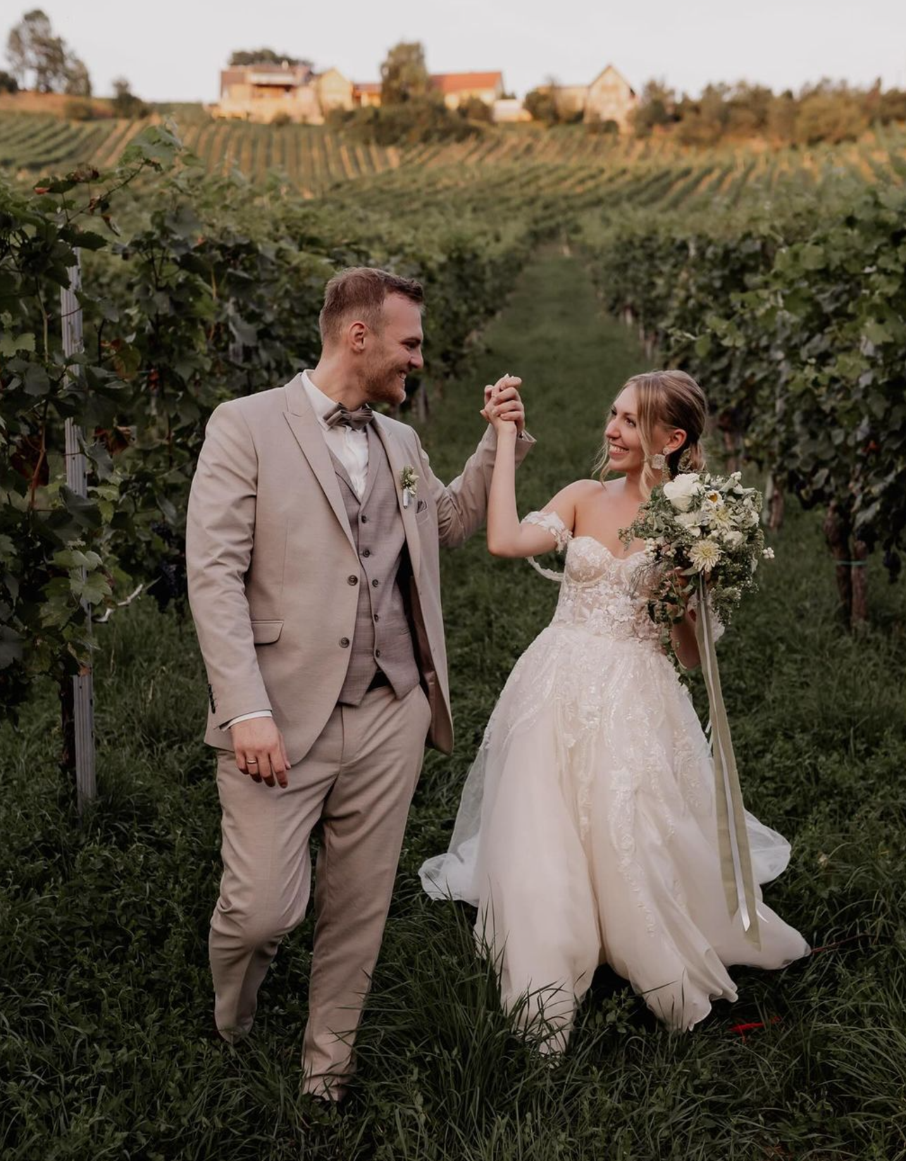 Glückliches Brautpaar bei einer österreichischen Hochzeit im Weinberg, strahlend vor Freude – zufriedene Kunden von AT Wedding, Linz