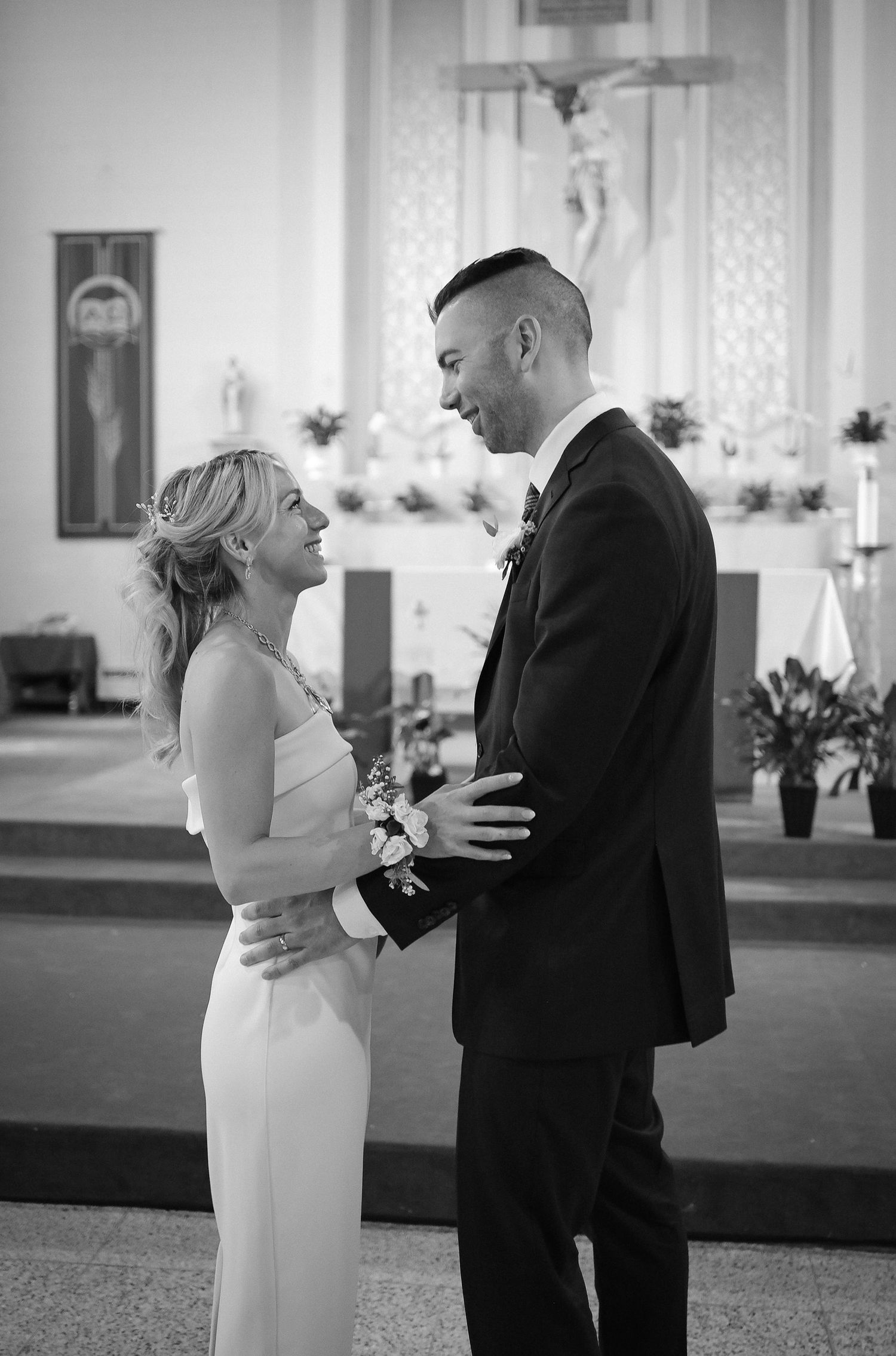 A beautiful black and white photo of newlyweds sharing a tender moment during their church wedding ceremony.