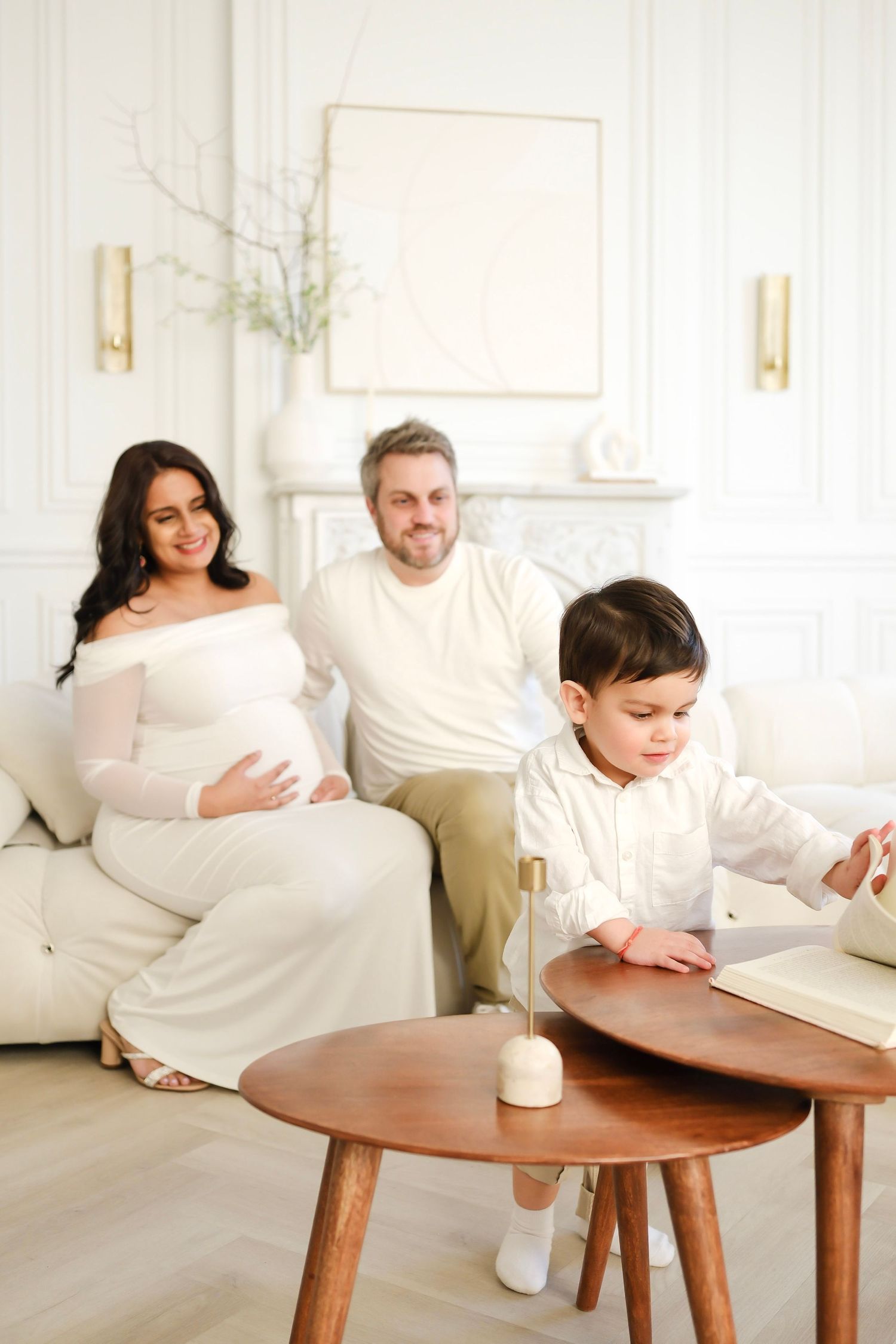 Family white couch in bright modern room with coffee table. Toronto, photographer, majestystudios, greater toronto area, maternity portrait