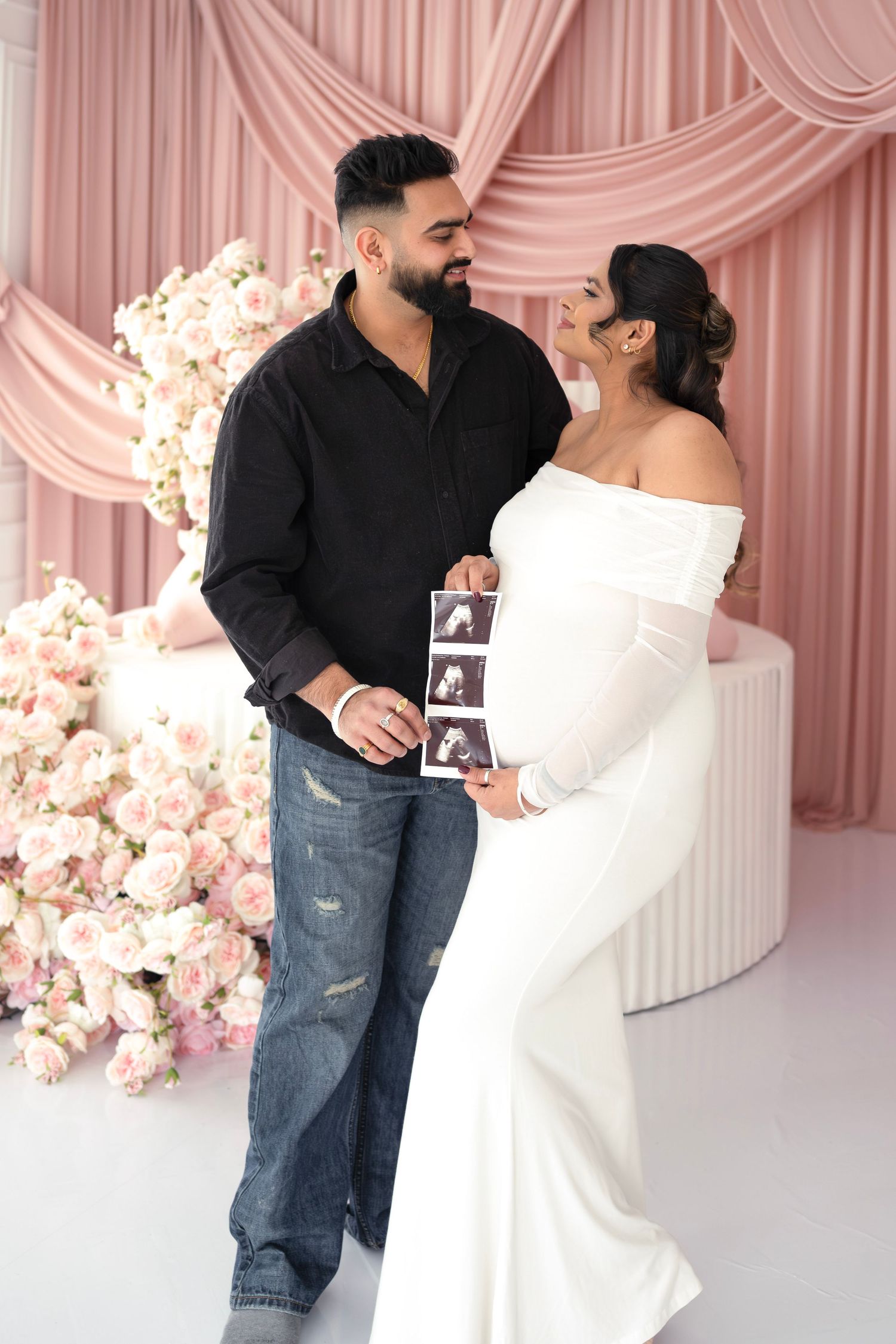 A couple in a romantic setting with pink curtains and cherry blossoms share a tender moment in three sequential photos.