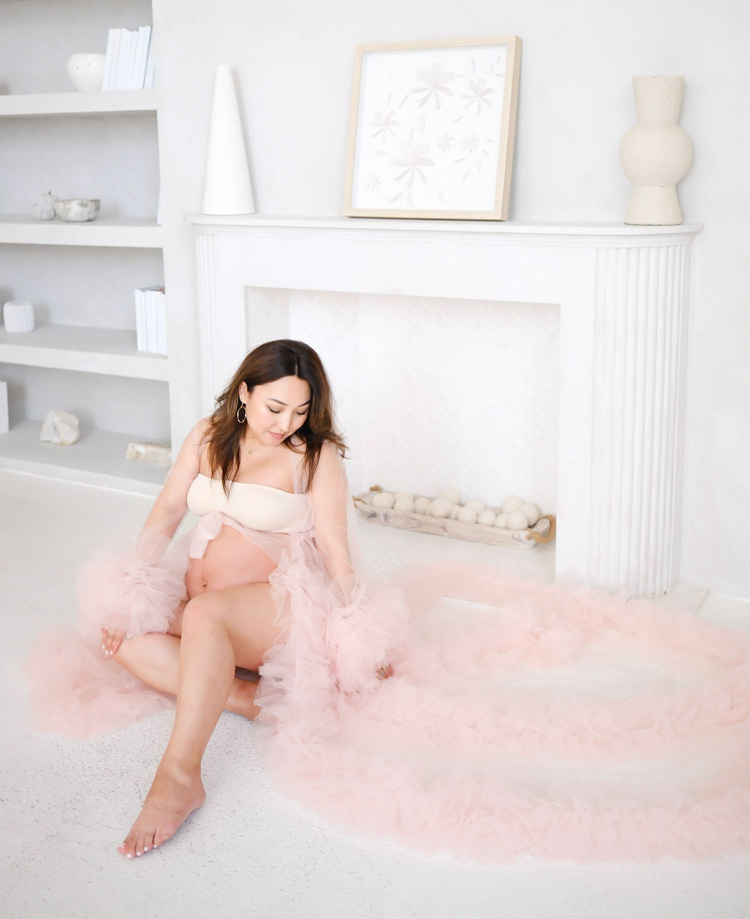 Dreamy boudoir photo featuring soft pink tulle in an elegant white room with fireplace.