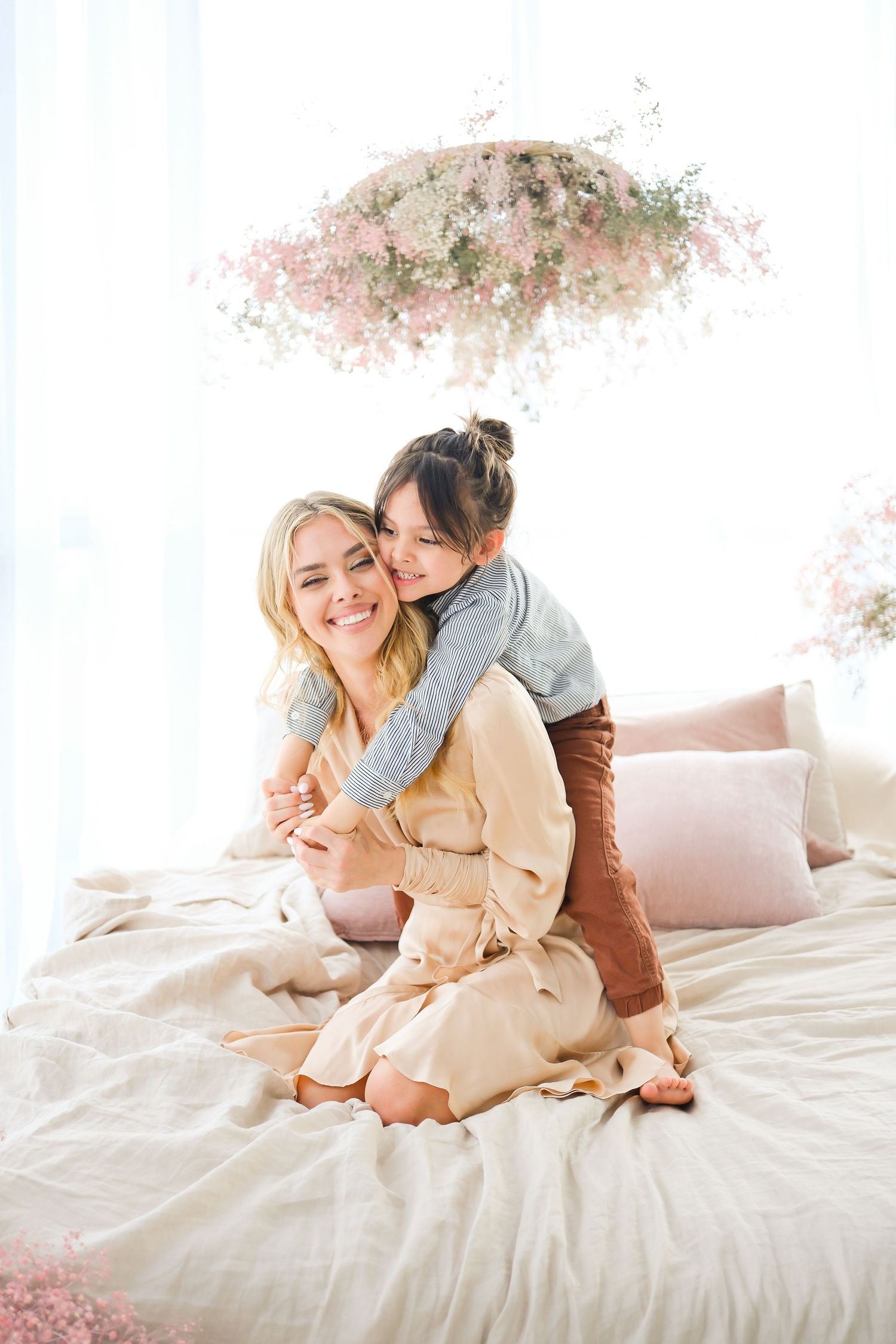 Tender moment shared on white bedding under floral decoration. Toronto, photographer, majestystudios, greater toronto area, family