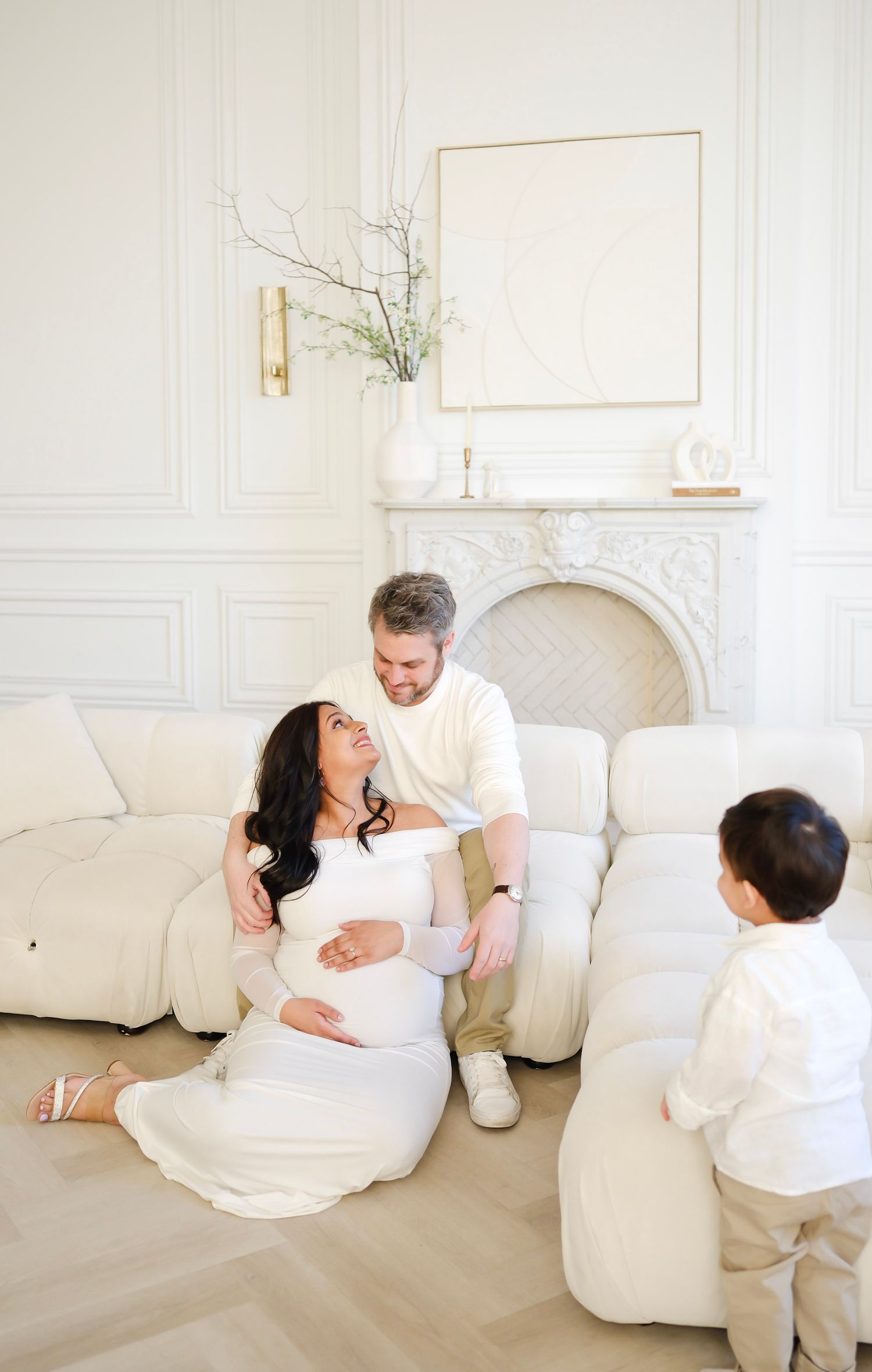 Family lounging together in elegant white room with marble fireplace. Toronto, photographer, majestystudios, greater toronto area, maternity
