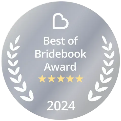 A circular silver badge displaying 'Best of Bridebook Award 2024' with five gold stars and decorative laurel wreath designs.