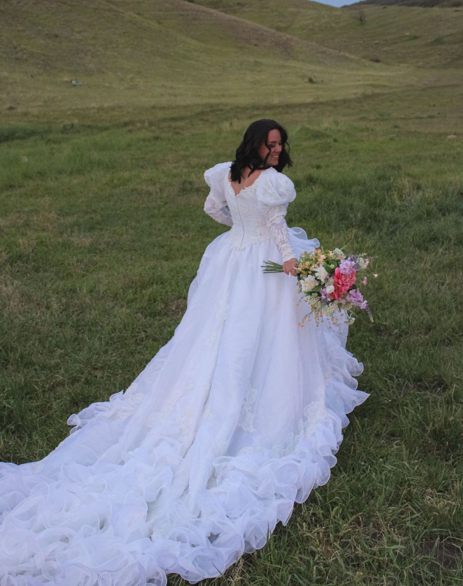 bride looking back at camera with bouquet in hands