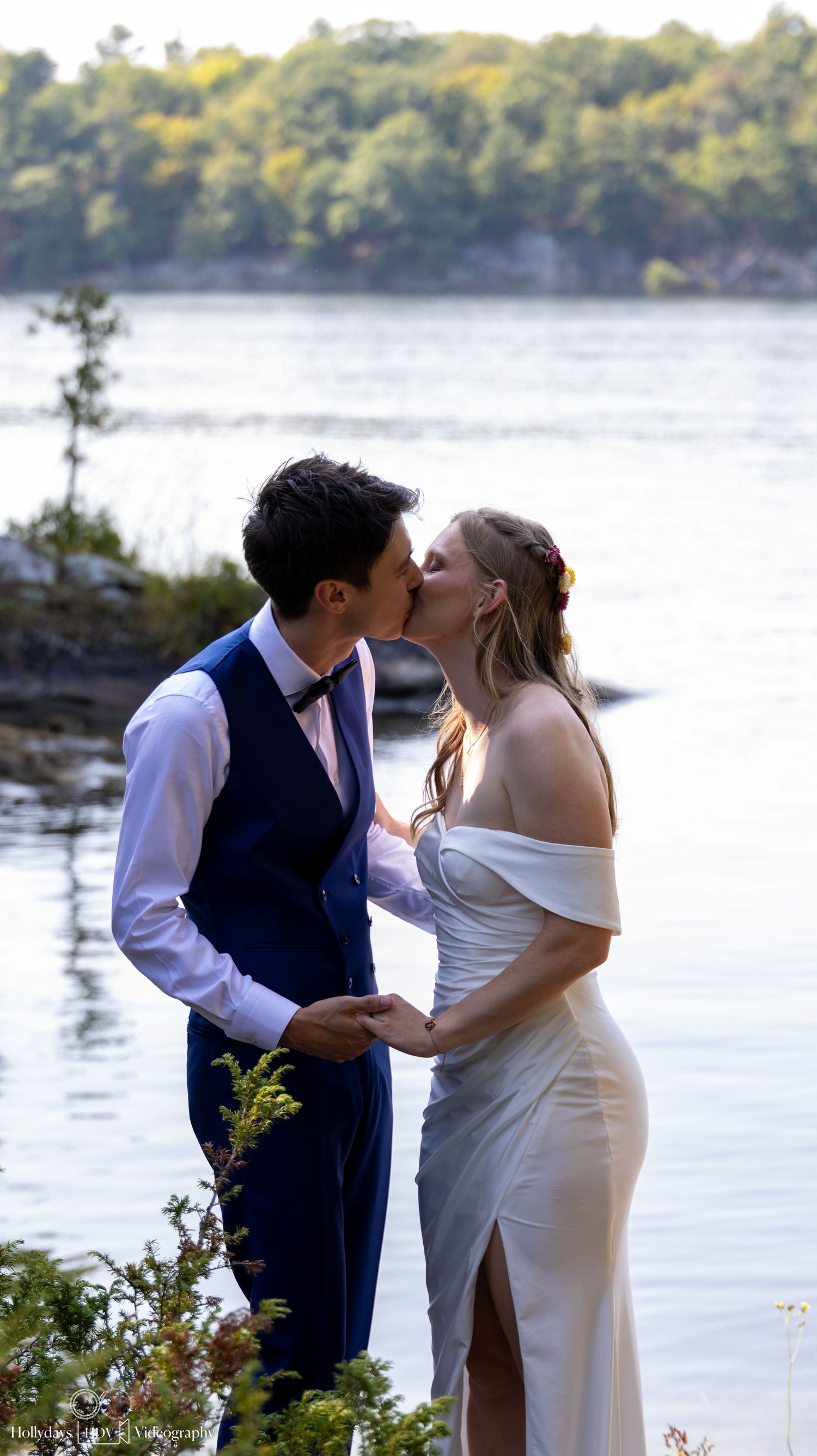 Romantic moment captured by lakeside with natural scenery in background.