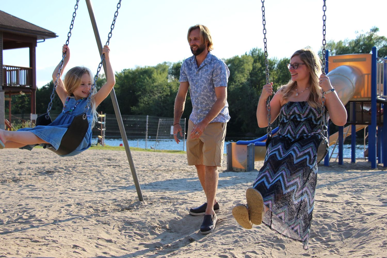Family enjoying time together at a playground with swings.