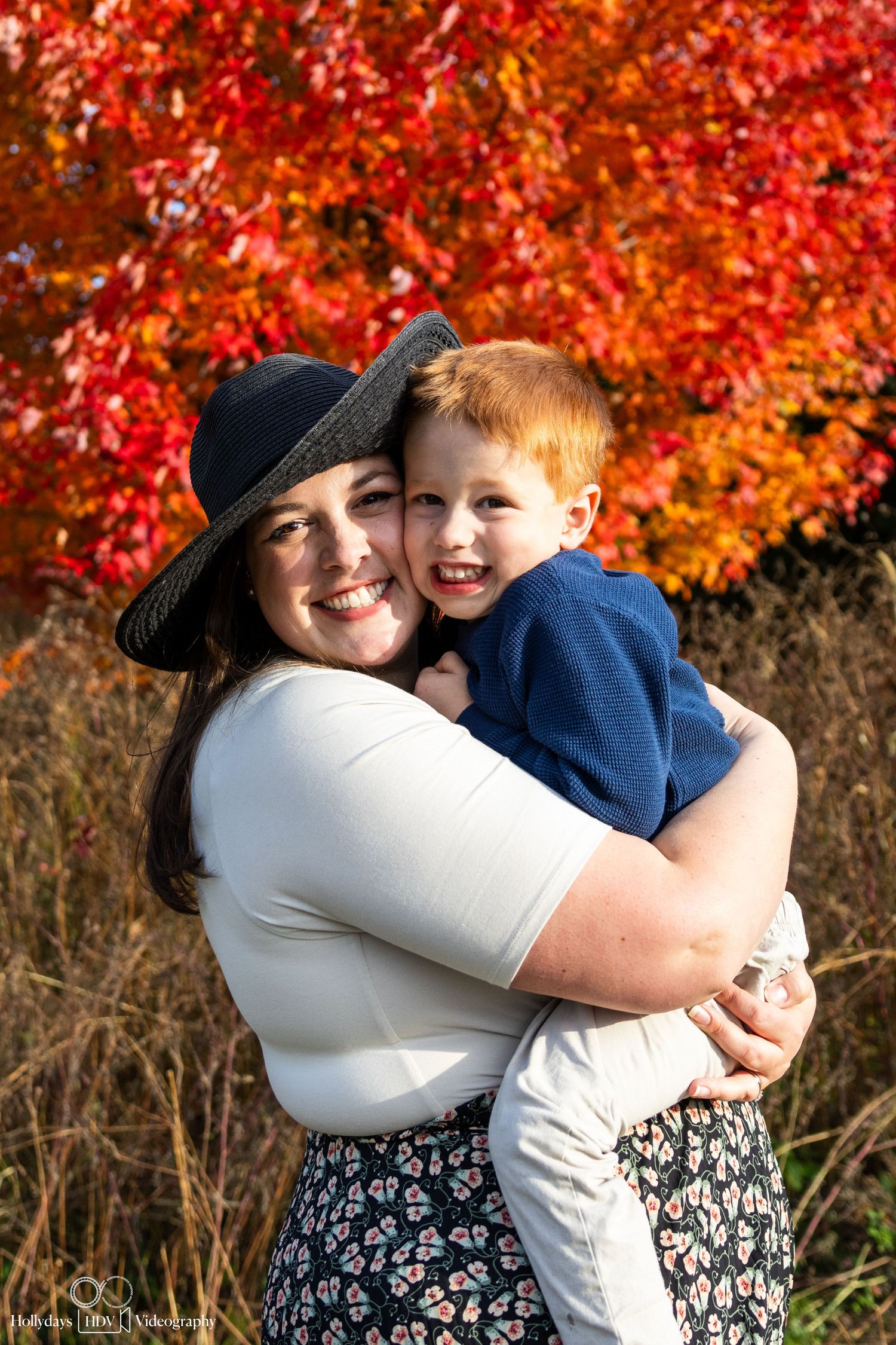 Outdoor portrait against autumn foliage wearing navy and white.