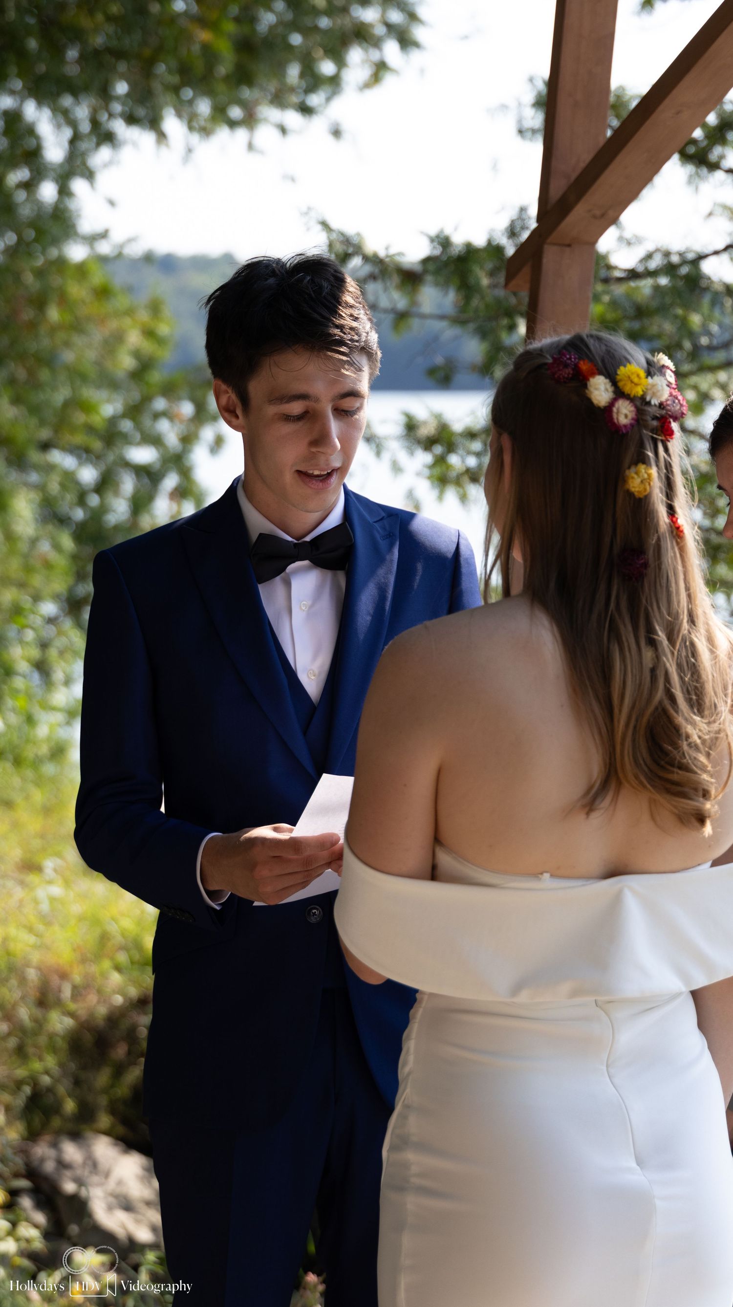 A couple exchanges vows during an intimate lakeside wedding ceremony.