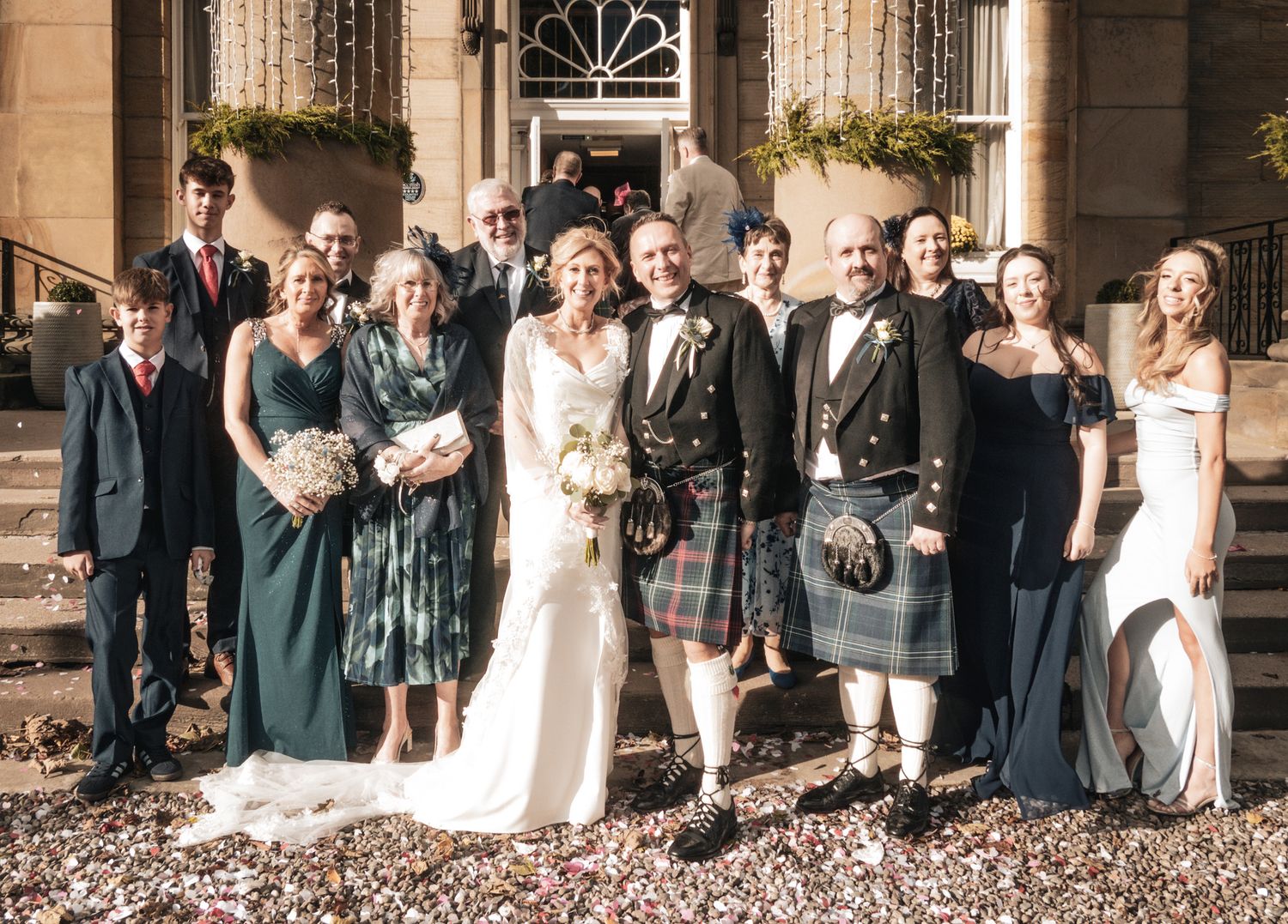 Bride and groom pose with family outside stunning Scottish Georgian mansion wedding venue.