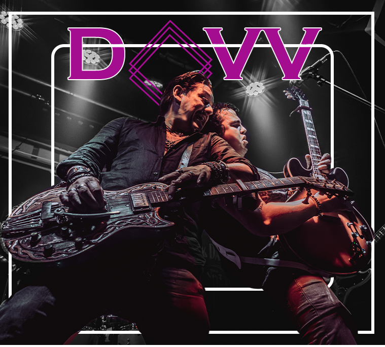 DAVV band logo with two guitarists performing on stage under dramatic lighting at a live concert.