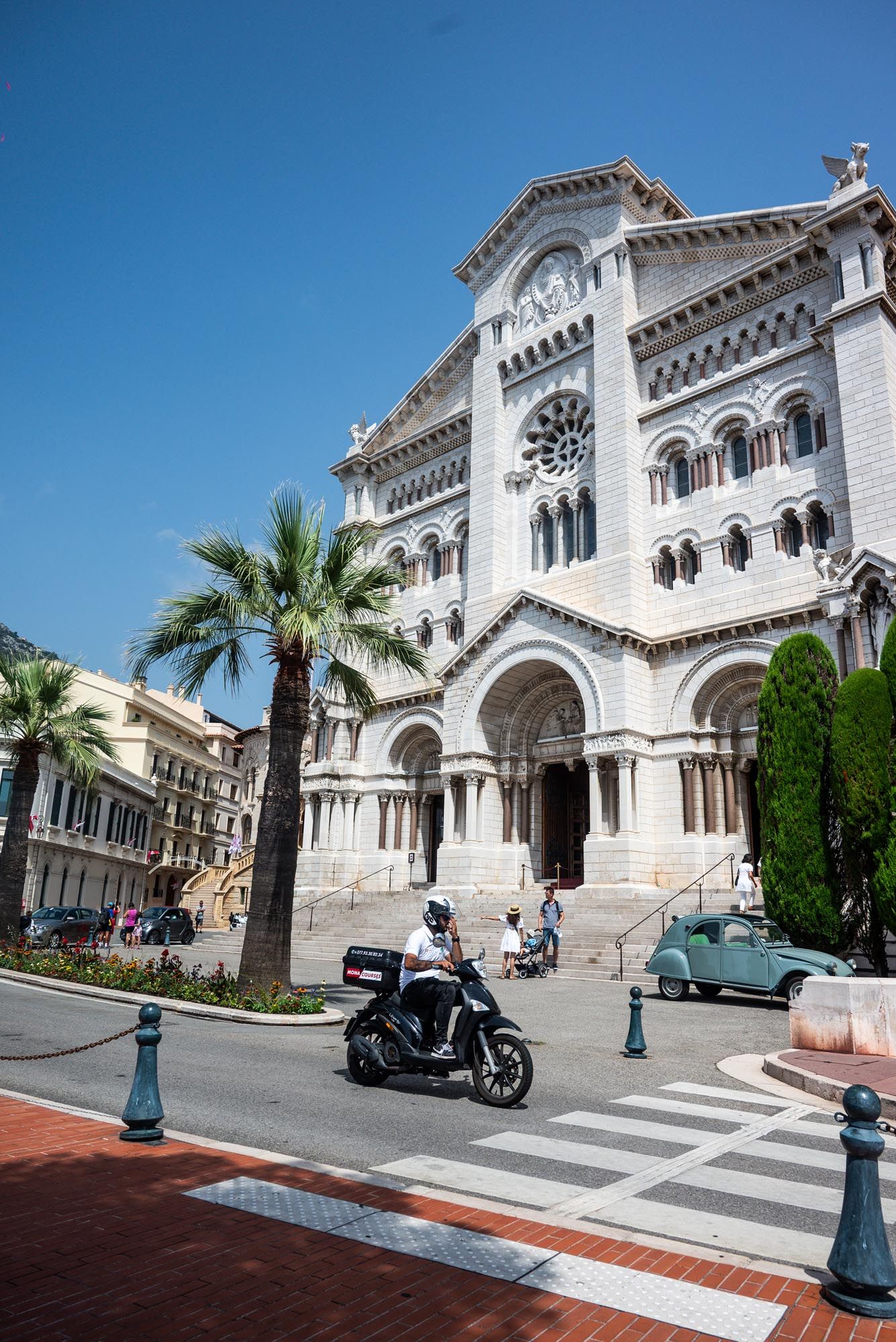 Saint Nicholas Cathedral in Monaco features white stone architecture and palm trees along its historic facade.