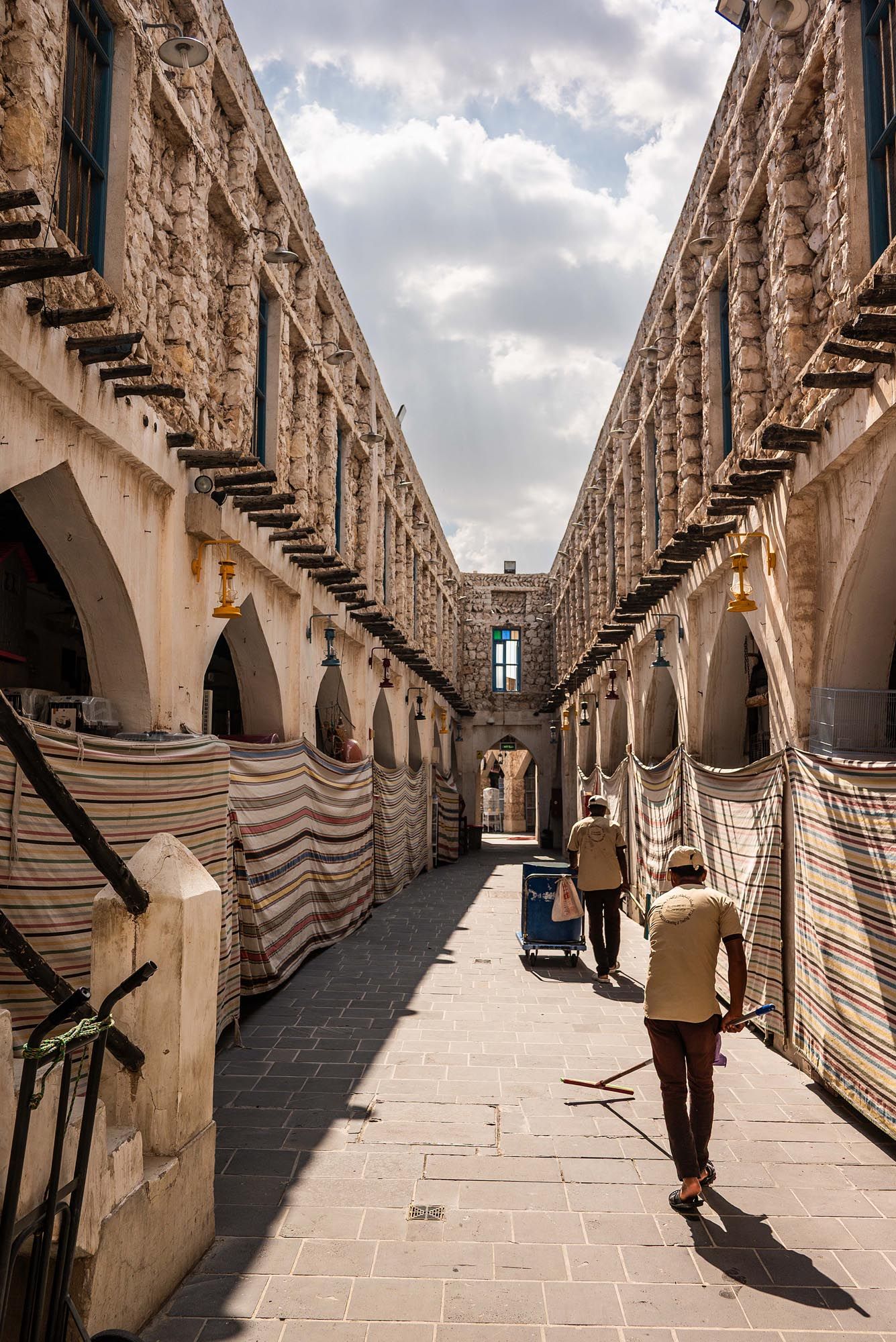 Architectural corridor with arched columns casting dramatic shadows on stone walkway at historic Cellular Jail in Port Blair.