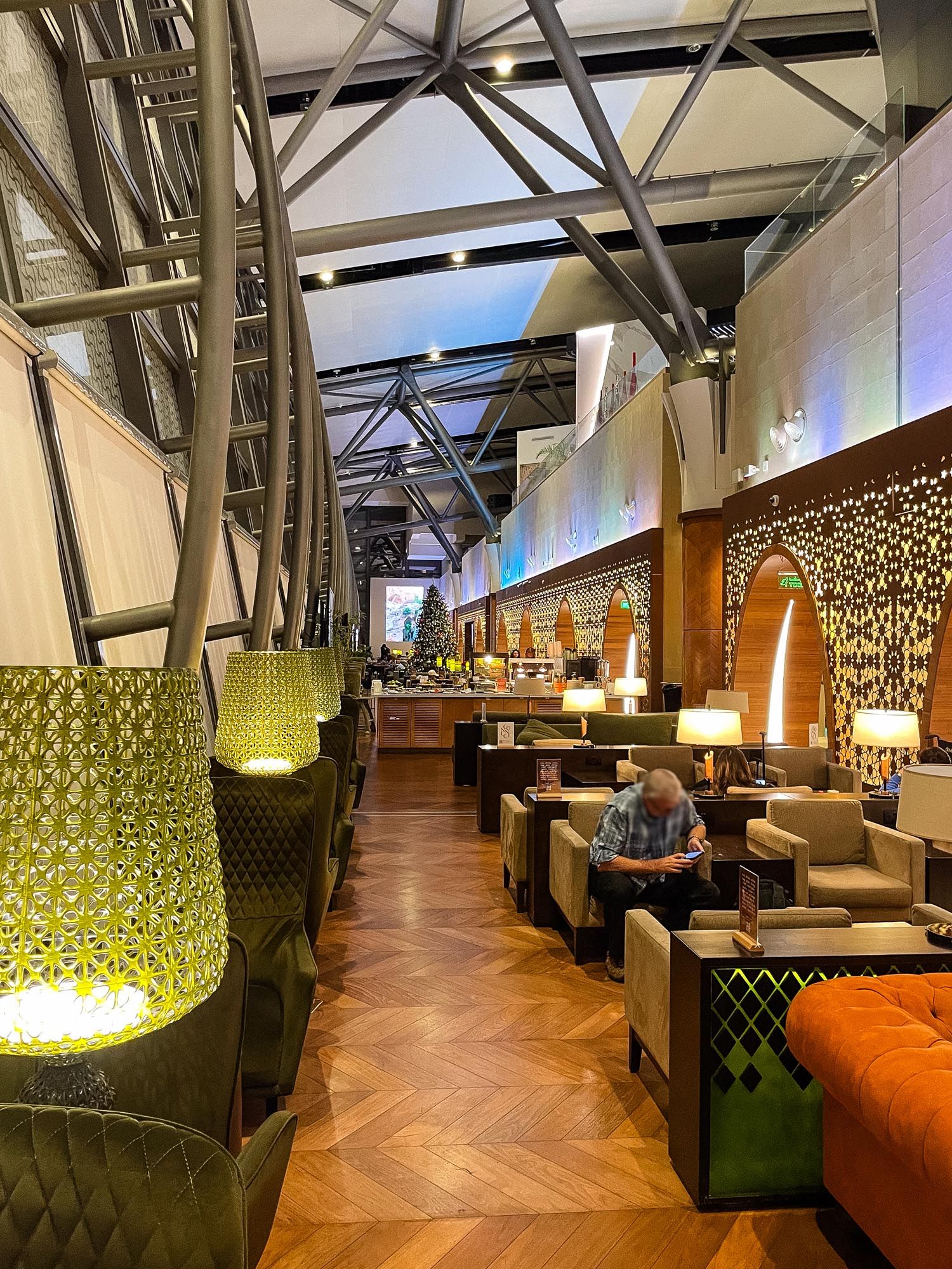 Modern airport lounge interior with comfortable seating, stylish lighting fixtures and geometric wall panels creates luxurious atmosphere.