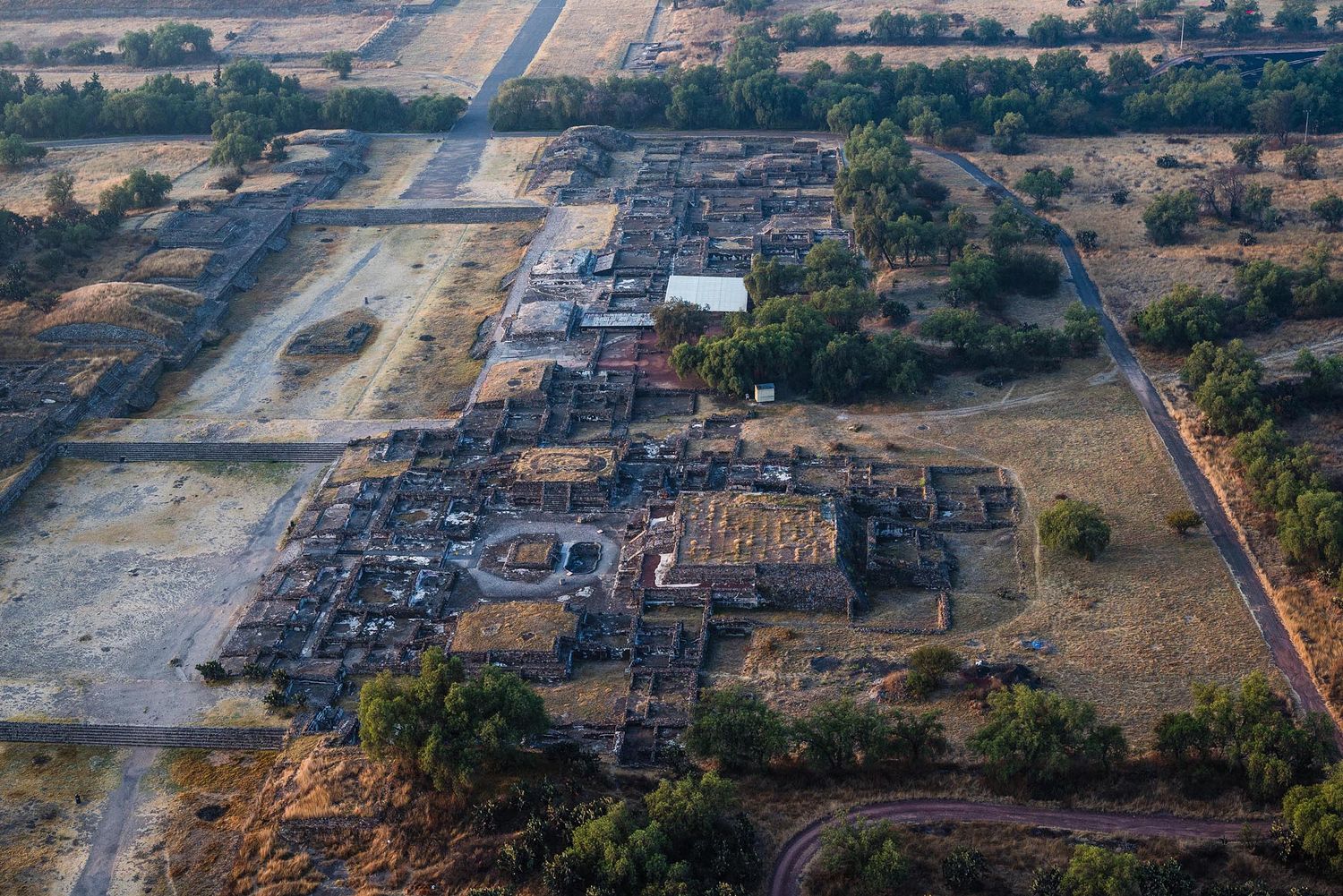 Aerial view of construction progress showing multiple stages of development at a large industrial site.