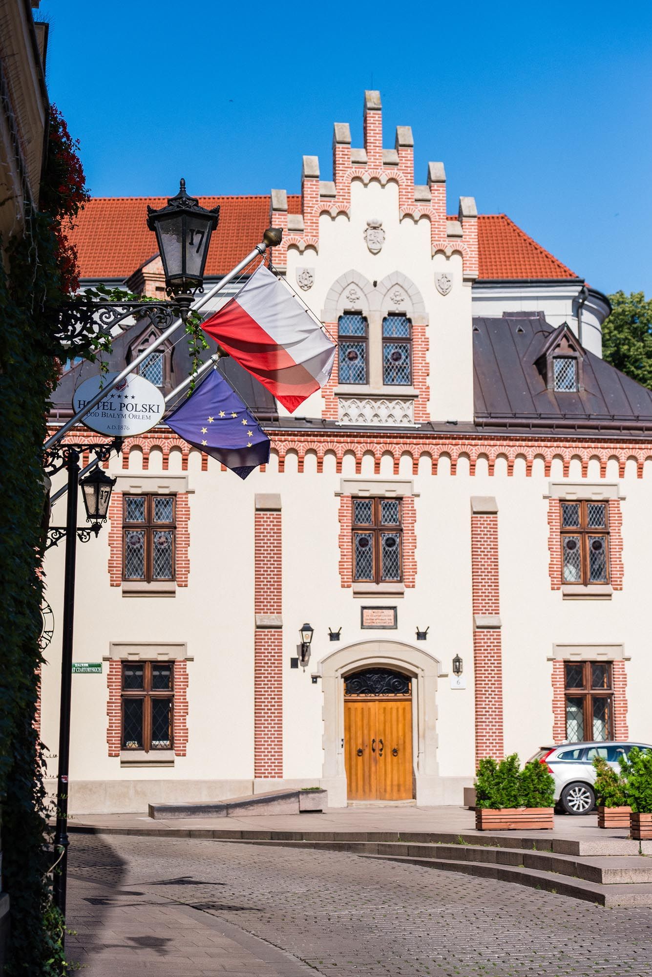 Historic pink and white building with stepped gable facade and wooden windows in European architectural style.
