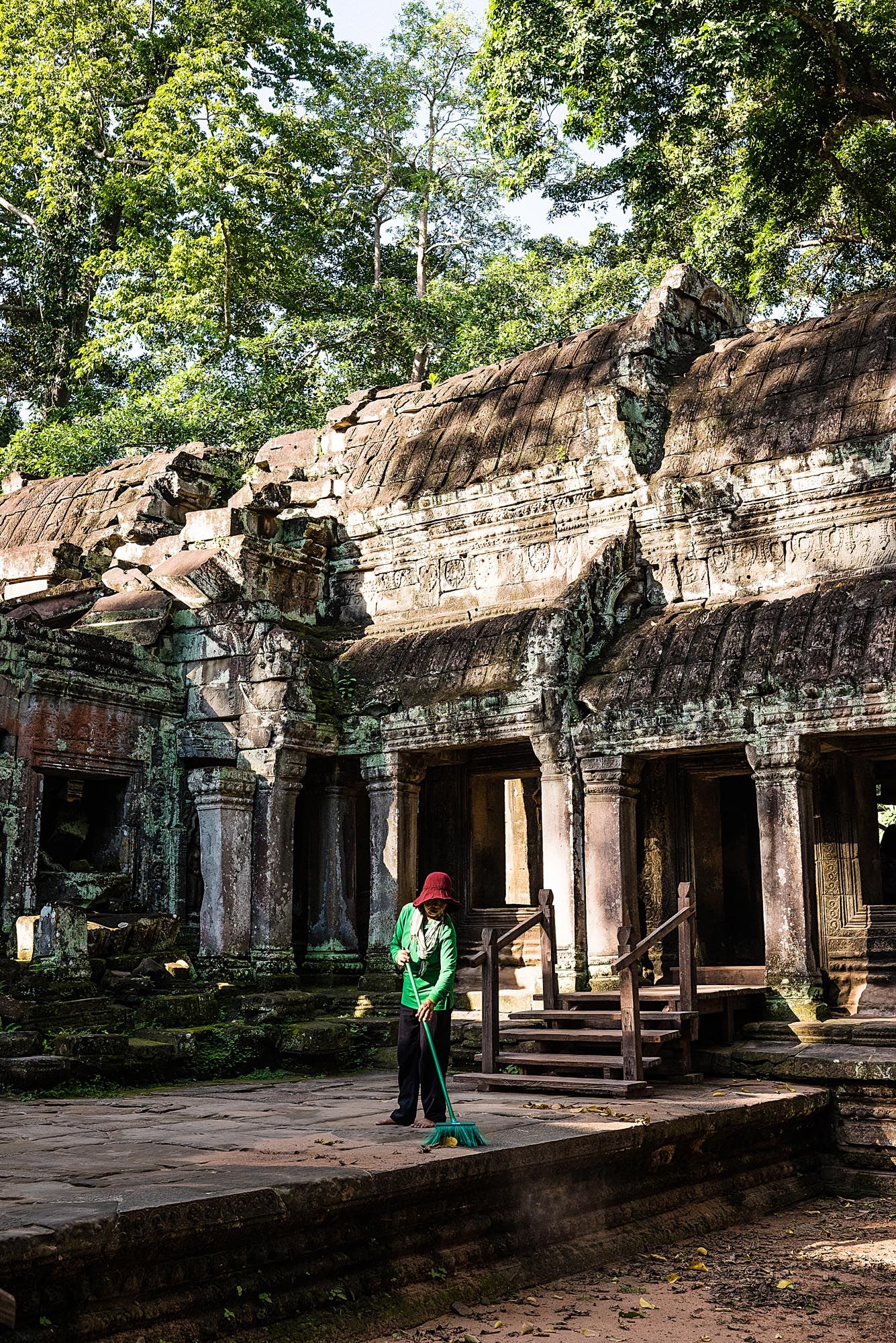 Ancient stone temple ruins with ornate carvings and columns at Angkor Wat archaeological site in Cambodia.