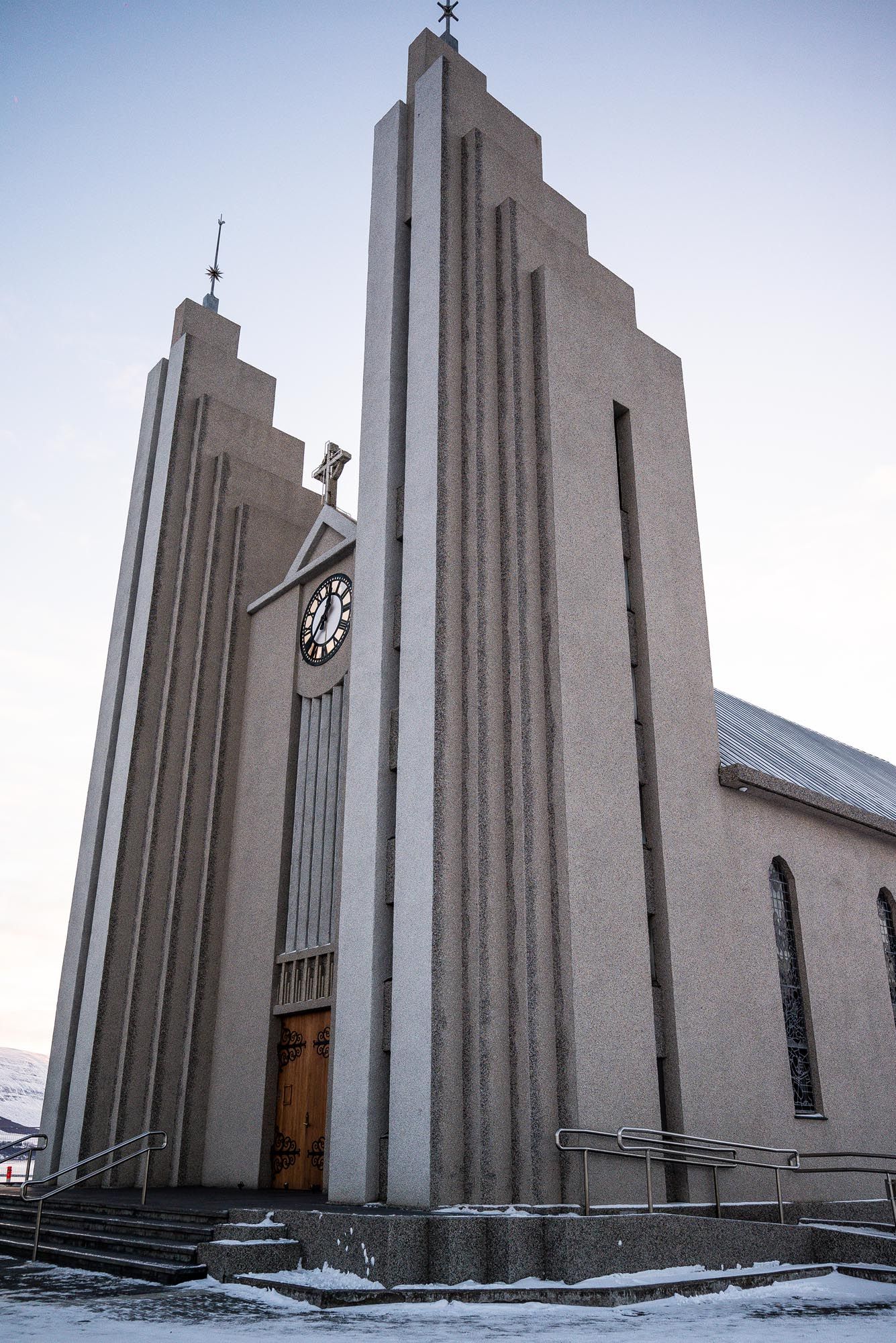 Modern white church with angular architecture and geometric lines photographed from different angles in snowy conditions.