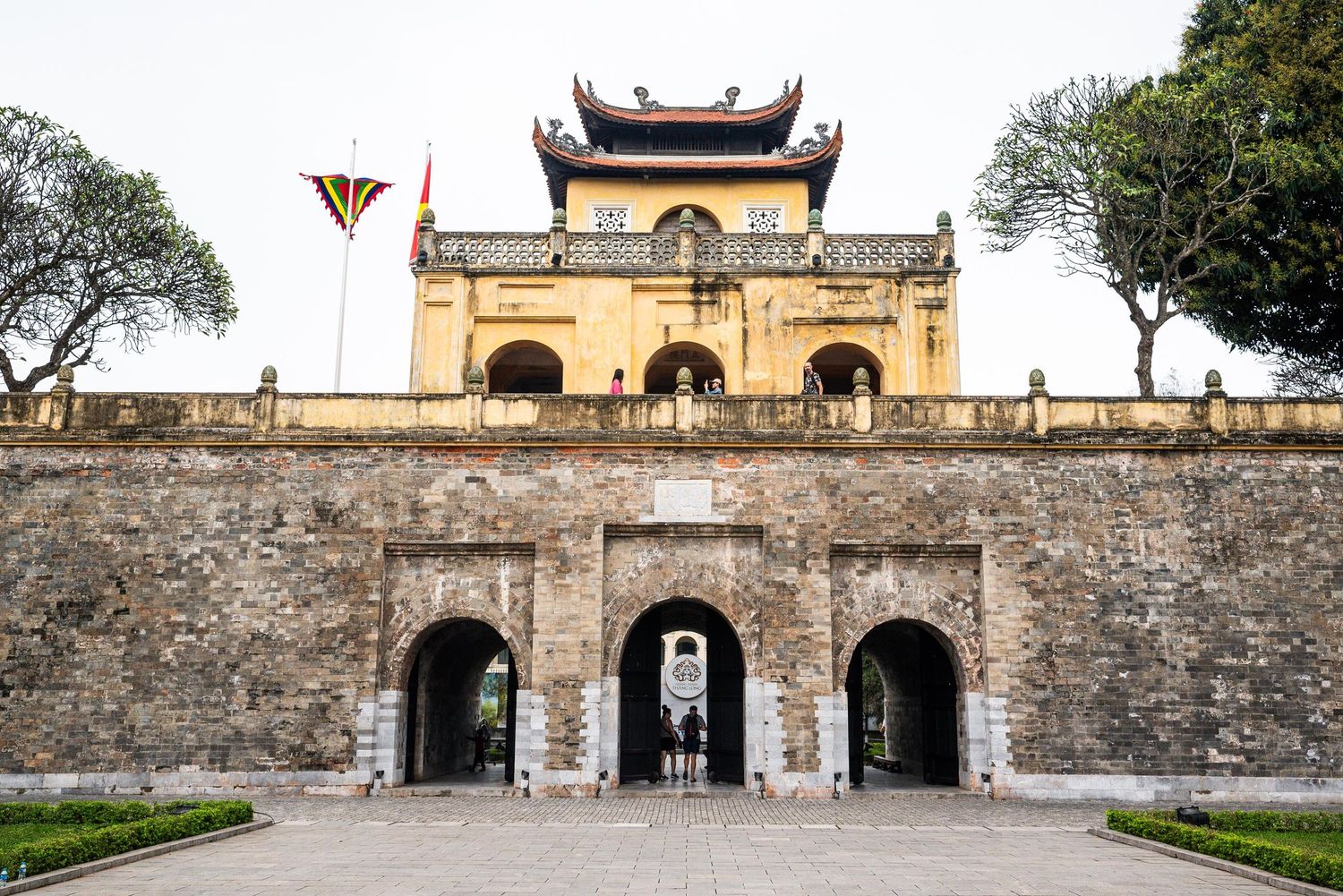 Ancient stone walls and gates of the Imperial Citadel in Hanoi feature traditional Vietnamese architectural elements.