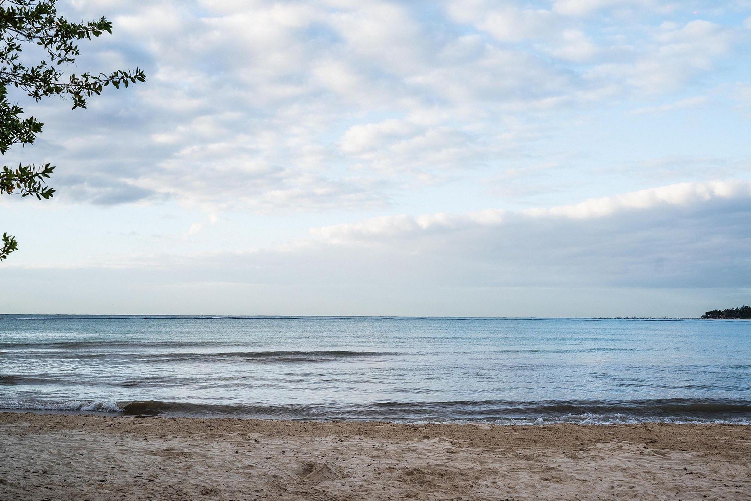 Panoramic sequence showing a cloudy beach landscape with waves rolling onto the shore at different times of day.