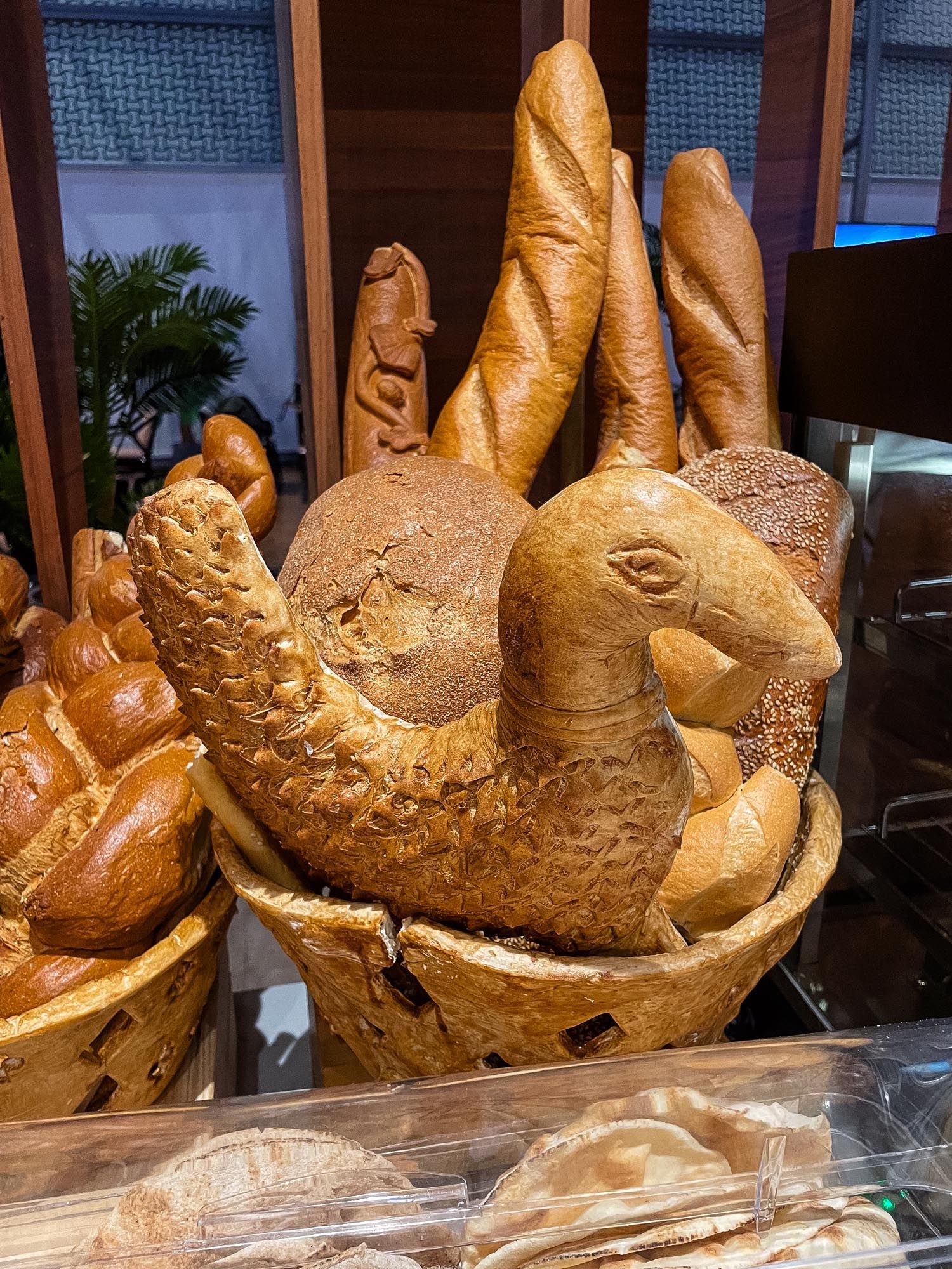 Golden brown bread loaves shaped like whimsical rabbits displayed in a bakery window.