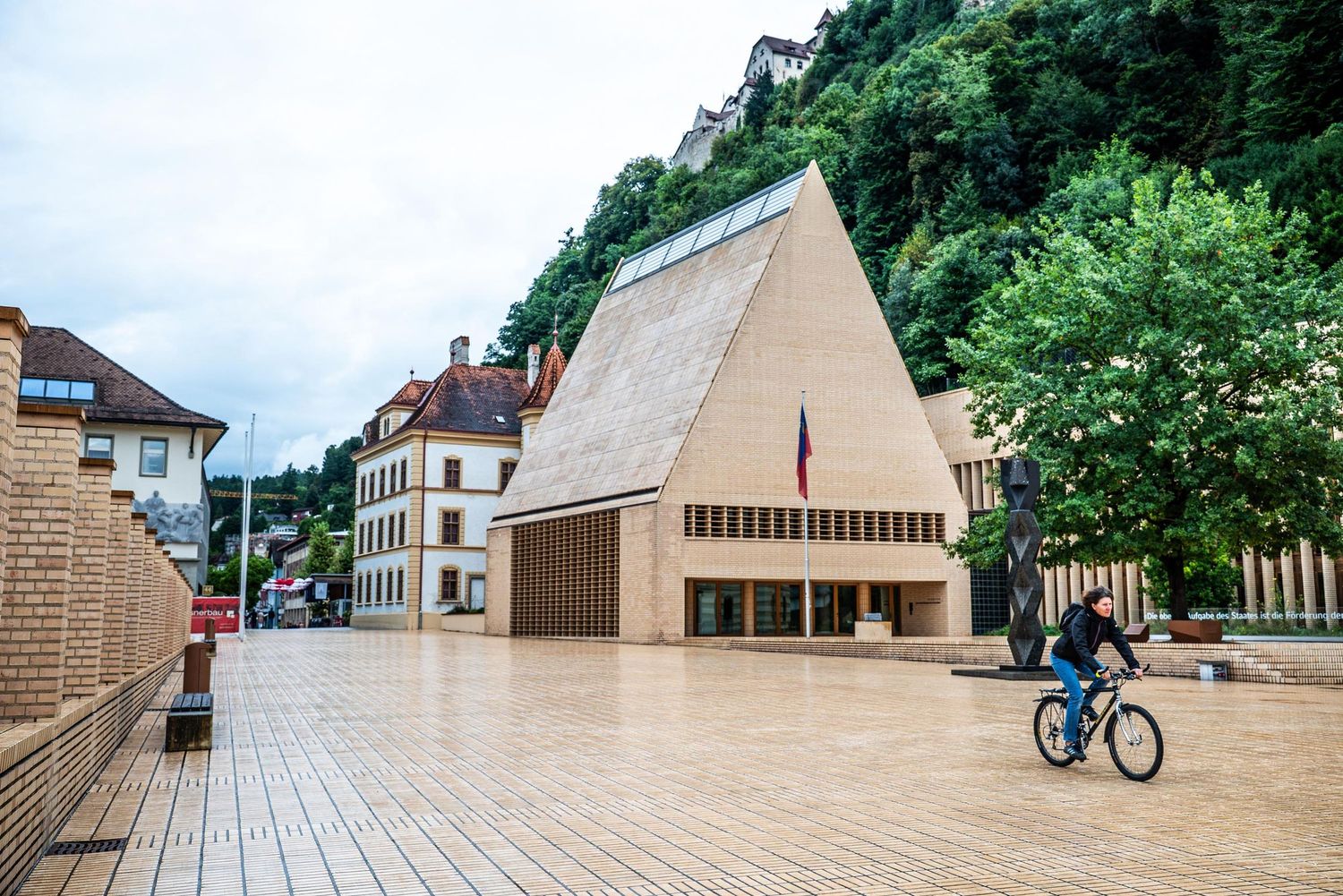 A panoramic view of a modern wooden architectural structure with angular design elements in an outdoor setting.