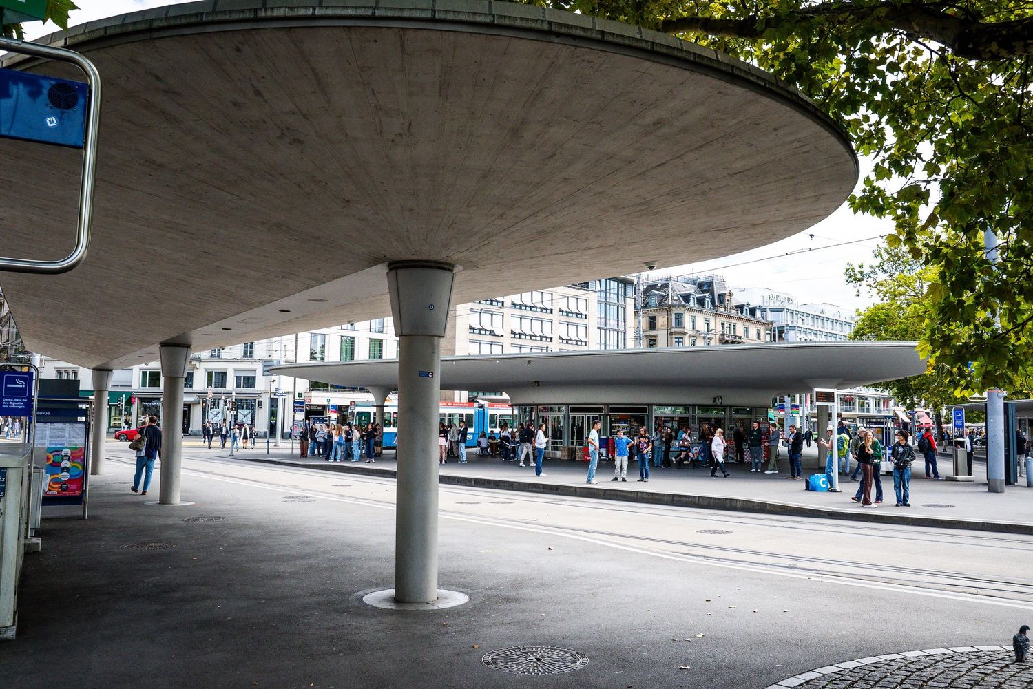 A panoramic view of a modern concrete underpass with curved architecture and pillars in an urban setting.