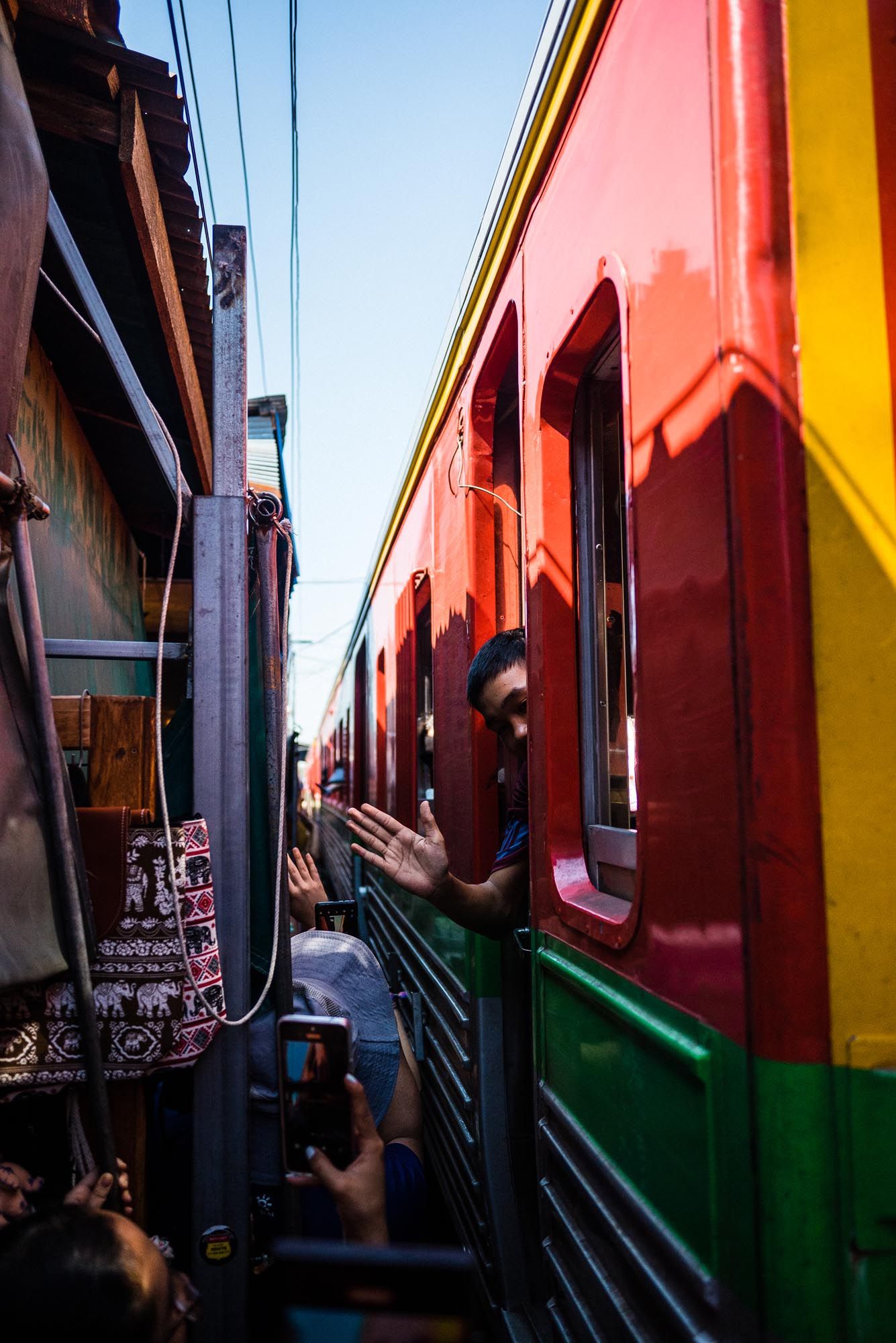Colorful train cars in red, yellow and green line up in sequence creating a vibrant geometric pattern.